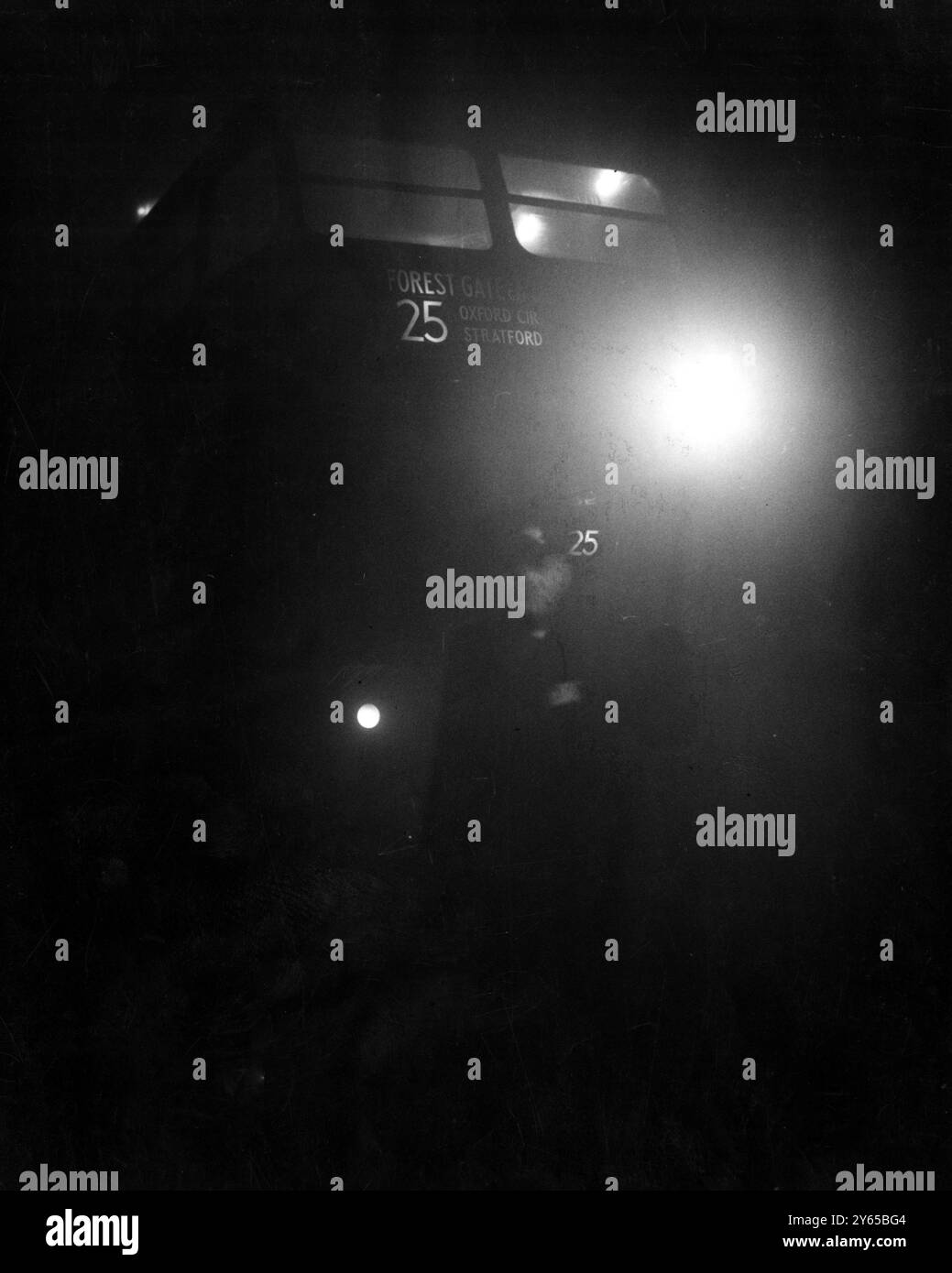 Flare-Weg durch den Nebel. Ein London Transport Inspector mit einem Fackel führt einen Bus aus der Endhaltestelle in Aldgate im Osten Londons , als wieder dichter Nebel London überdeckte und ein weitverbreitetes Verkehrschaos verursachte . 8. Dezember 1952 Stockfoto