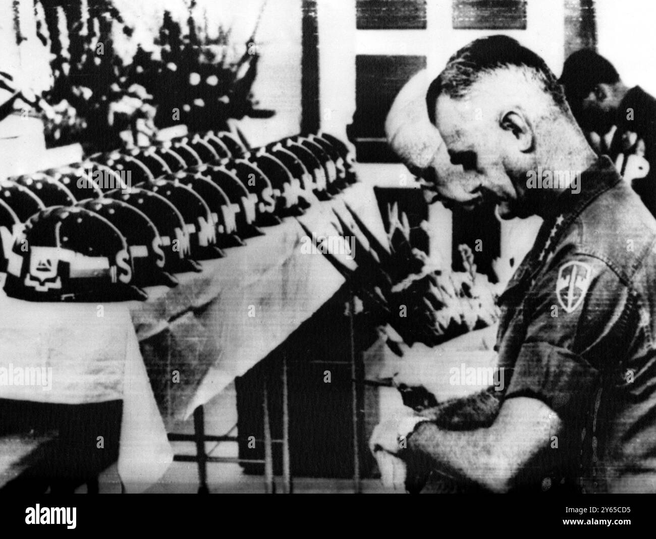 Schmerzhafte Erinnerung Saigon - General William C Westmoreland (nächster) und US-Botschafter in Südvietnam Ellsworth Bunker knien im Gebet während der Gedenkfeier hier am 13. Februar 1968 für 27 US-Marinesoldaten, die während der Öffnungszeiten der Schlacht um Saigon getötet wurden. Symbolische Helme stellen die Toten am 14. Februar 1968 dar Stockfoto