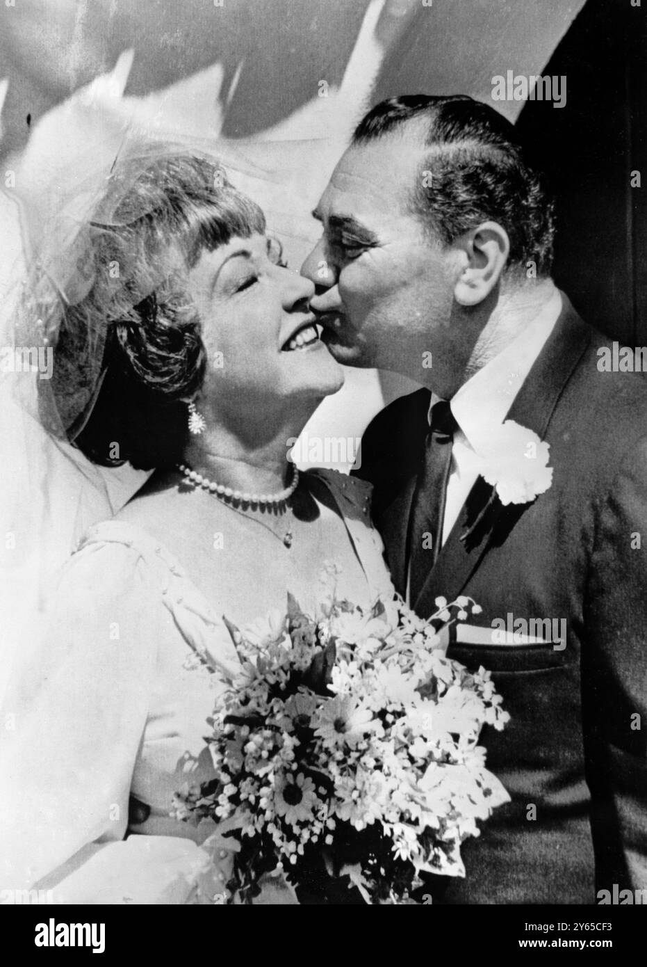 Oscar-Gewinner Ernest Borgnine pflanzt einen Kuss auf die Wange seiner Braut, dem Broadway-Musical-Star Ethel Merman, nach ihrer Hochzeit in Beverly Hills, Kalifornien am 27. Juni 1964 Stockfoto
