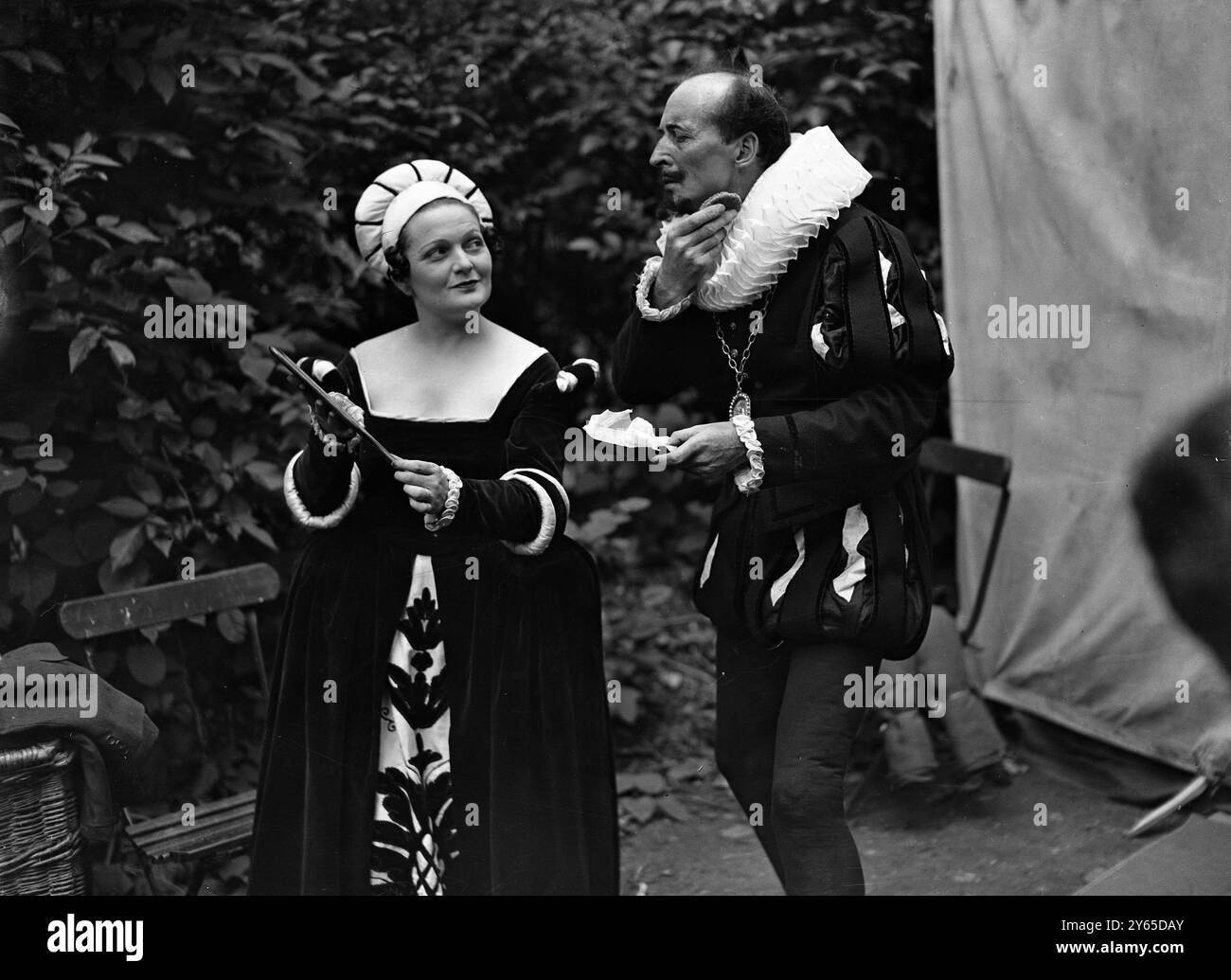 Shakespeare im Freien. " Twelfth Night " im Botanischen Garten , Regent ' s Park , London . " Maria " ( Clare Harris ) hilft " Malvolio " ( Arthur Wontner ) beim Aufmachen . 1936 Stockfoto