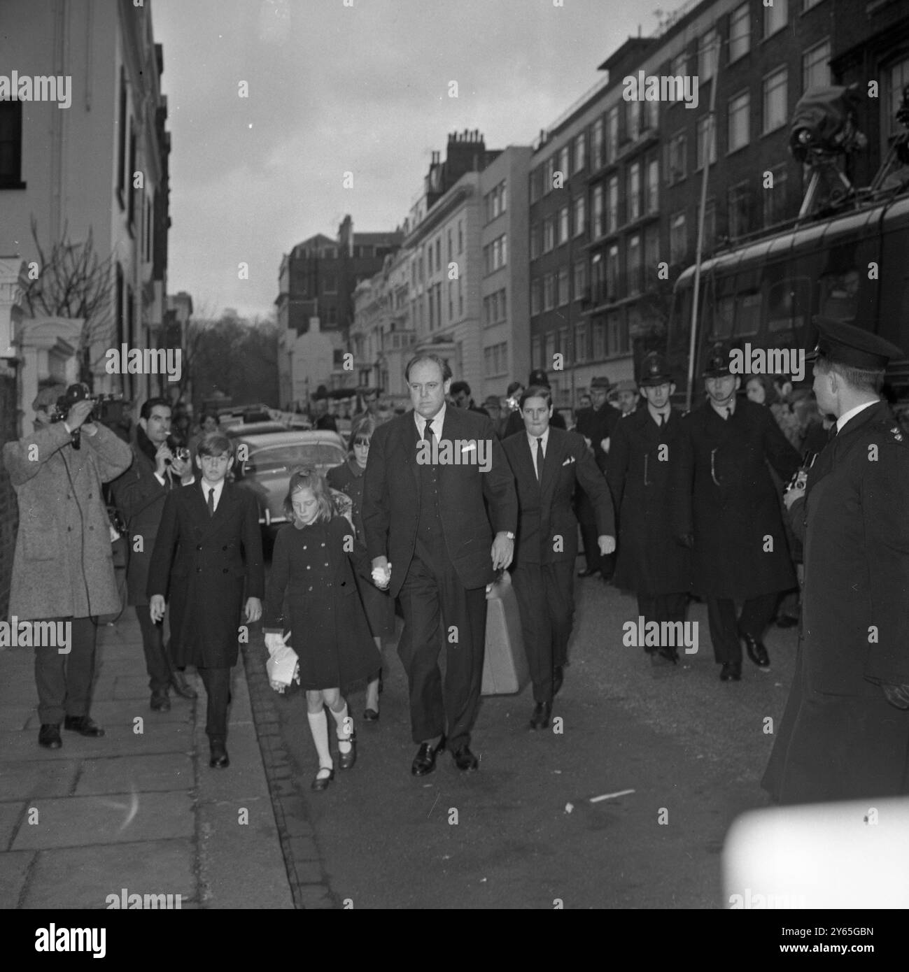 Blumen für Sir Winston seit Sir Winston Churchill einen Schlaganfall erlitten hat , hat sich die Flut von Blumen und Beileidsbekundungen in Nr. 28 , Hyde Park Gate , gegossen , wo der 90-jährige Staatsmann schwer krank ist , und Mrs Annie Shaw , 82 , eine ehemalige Schwester aus Oldham , Lancashire , Hand in Blumen in Sir Winstons Haus . Januar 1965 Stockfoto