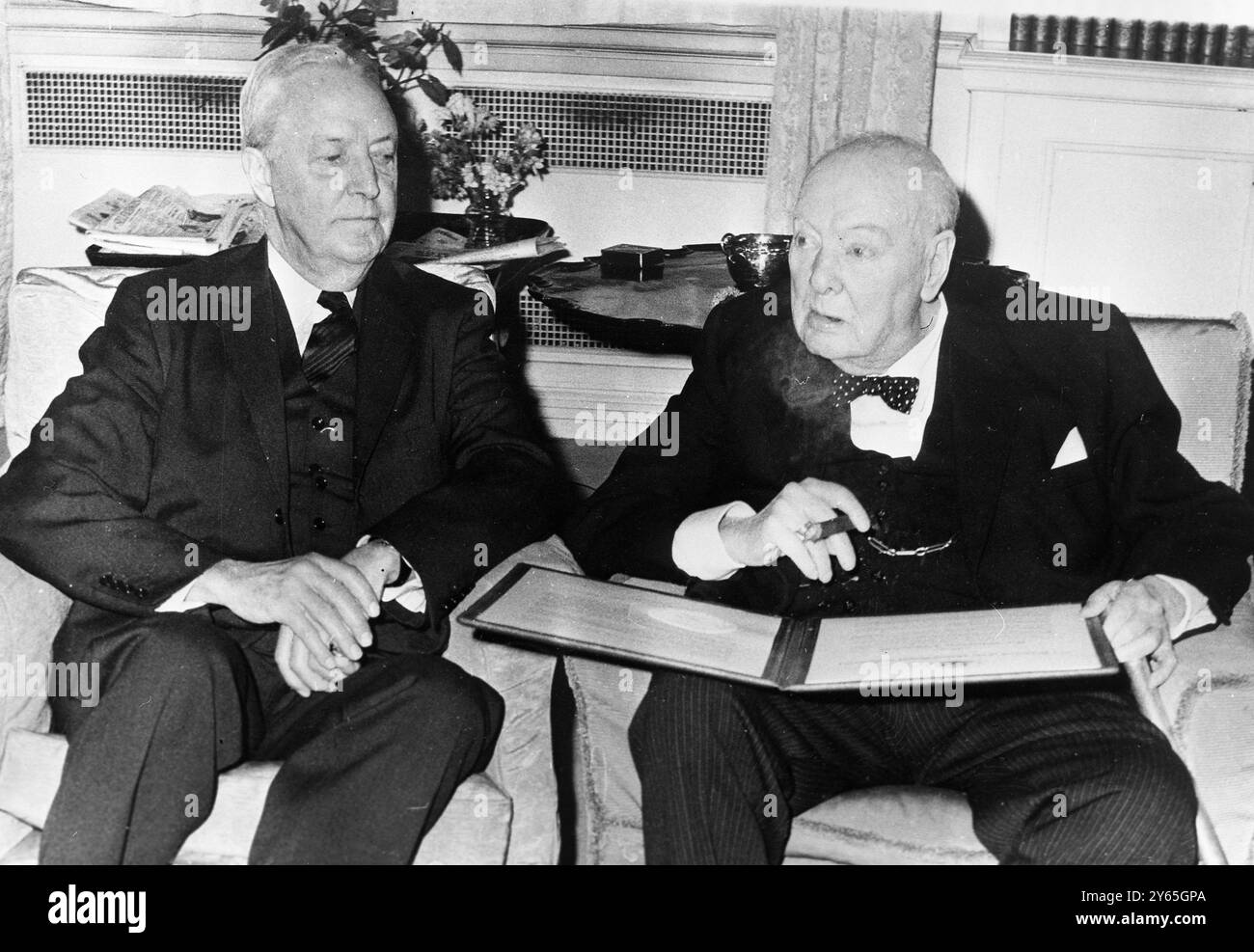 Sir Winston Churchill ( rechts ) mit dem US-Botschafter in Großbritannien David Bruce ( links ) blickt durch das historische Dokument und macht ihn zu einem Ehrenbürger der Vereinigten Staaten bei einer Verleihung in seinem Haus im Hyde Park Gate in London . April 1963 Stockfoto