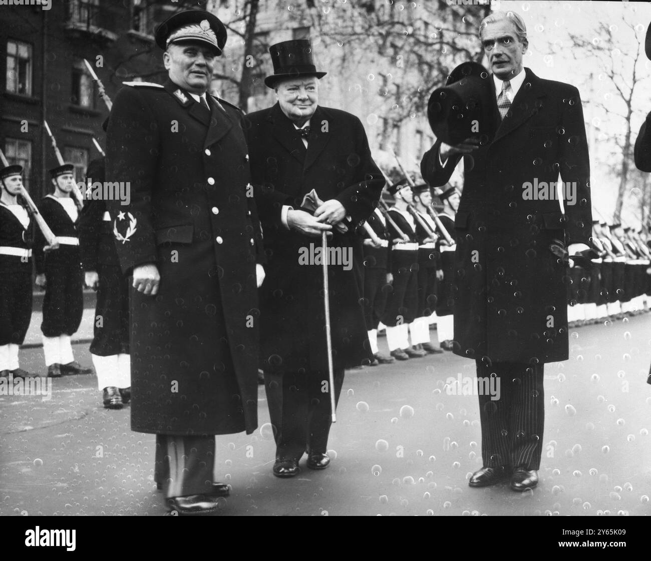 Eden und Churchill begrüßen Marschall Tito Außenminister Anthony Eden ( rechts ) nimmt seinen Hut ab als Jugoslawiens Marschall Tito ( links ) von Premierminister Winston Churchill begrüßt wird , nachdem Tito vom Start der Port of London Authority , " The Nore " am Westminster Pier gelandet war , nachdem er die Themse hinaufgesegelt hatte . Der Herzog von Edinburgh war auch bereit, den Marschall bei seiner Ankunft zu einem fünftägigen offiziellen Besuch zu begrüßen. 16. März 1953 Stockfoto