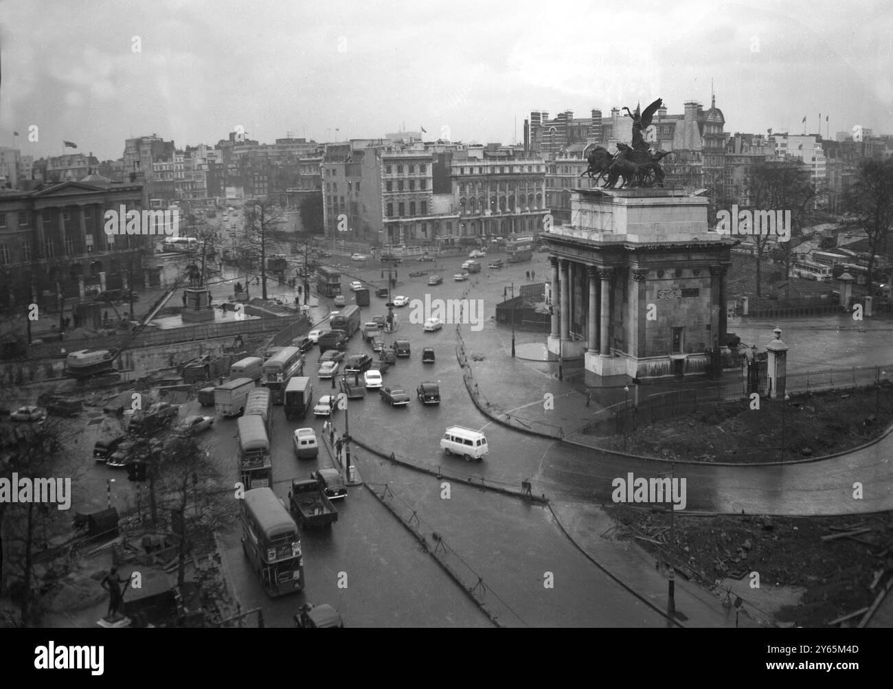 London Traffic über die Straße um den Wellington Arch. Kräne und Bauarbeiten sind zu sehen, wenn mit dem Bau der neuen Unterführung begonnen wurde . Es war ein Abschnitt der weiter gefassten Marble Arch - Park Lane - Hyde Park Corner Road, die weiter ausgebaut wurde. Dies war Teil eines Plans zur Verringerung der Verkehrsstaus auf den Straßen im Zentrum Londons . Es wurde 1962 am 6. Februar 1961 eröffnet Stockfoto