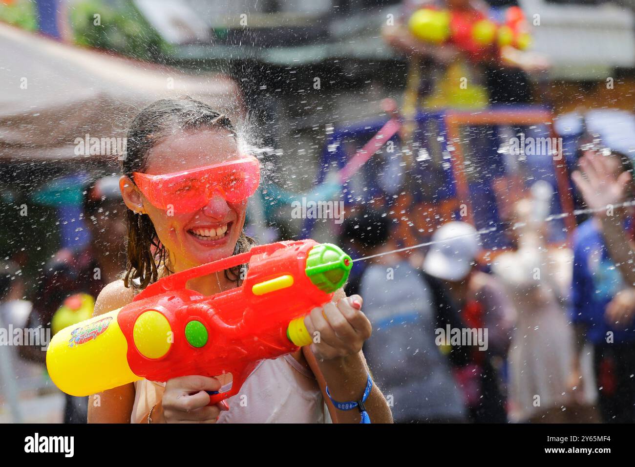 Bangkok, Thailand - 13. April 2023: Frauen spritzen Wasser mit einer Wasserpistole während des traditionellen Songkran Festivals, Thai New Year, in der Khaosan Road. Stockfoto