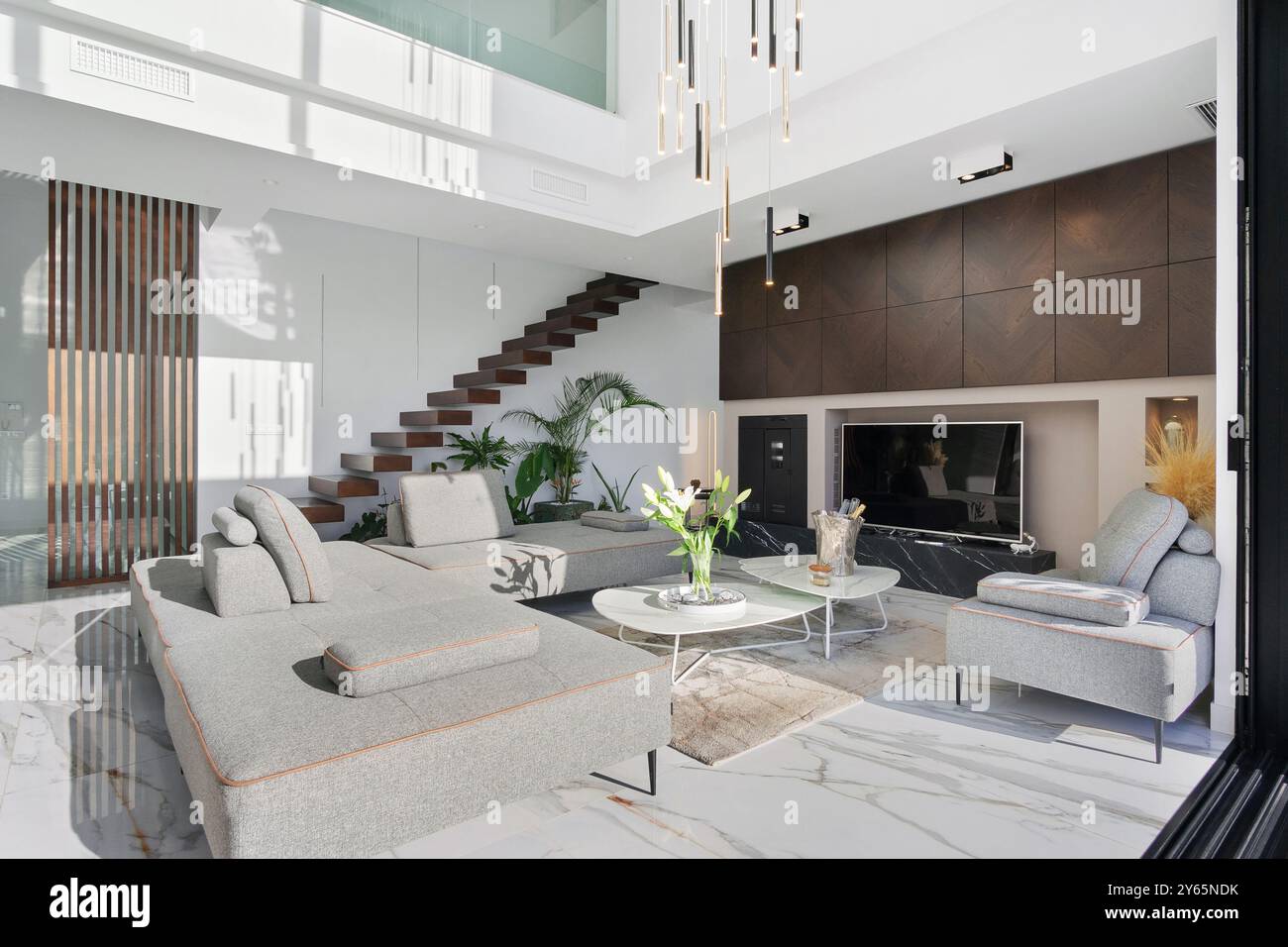 Dieses Foto zeigt ein hochwertiges, modernes Wohnzimmer in einer luxuriösen Villa mit eleganten Möbeln, elegantem Dekor und einer spektakulären Architektur Stockfoto