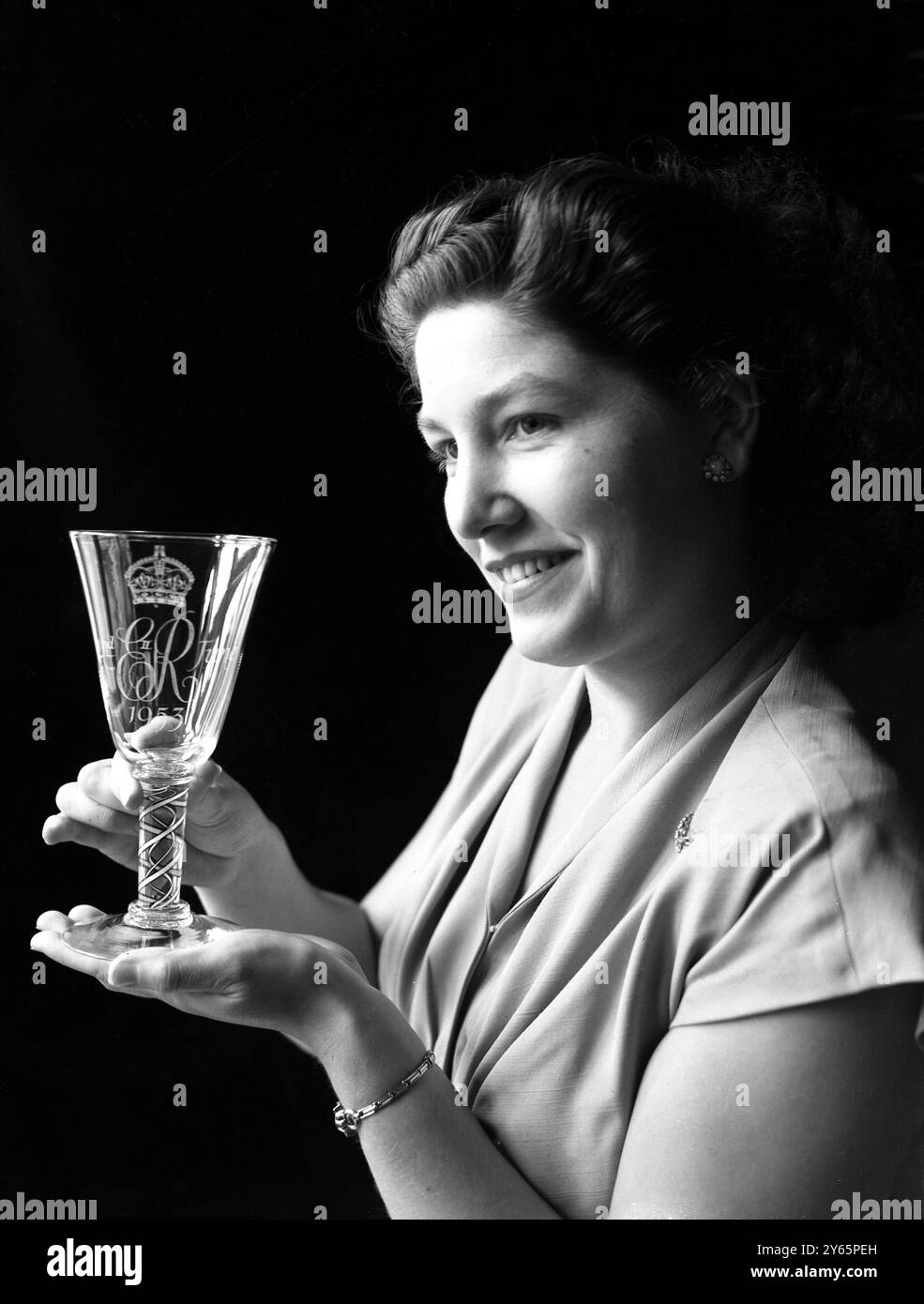 Die Sammler werden seltene Souvenirs der Krönung haben - exquisite Kelche in Diamantspitze geätzt und mit der Chiffre EIIR am 2 . Juni 1953 , überragt von der Königlichen Krone . Die Kelche der Glashütte Whitefriars , Wealdstone , Middlesex produziert Frank Hill , einer der führenden Glasbläser der Welt . Das Bild zeigt: Frau Maureen Bullock (von Bristol) hält einen der exquisiten Krönungskelche am 30. Juli 1952 Stockfoto