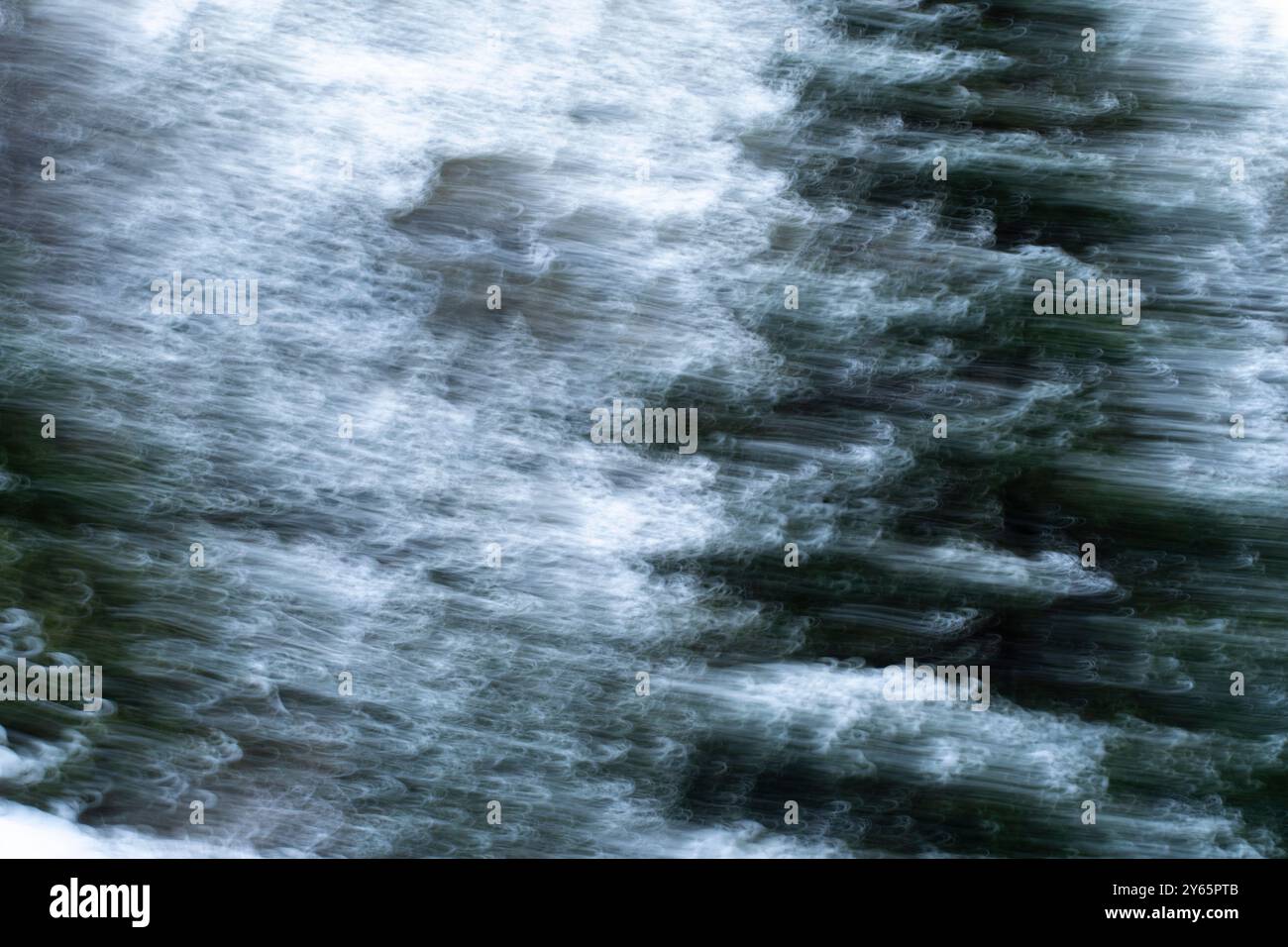 Dieses abstrakte Bild zeigt eine verschwommene, fließende Schneetextur, die in Graustufen und Grün erfasst wird und ein Gefühl von Bewegung und Fließfähigkeit vermittelt Stockfoto
