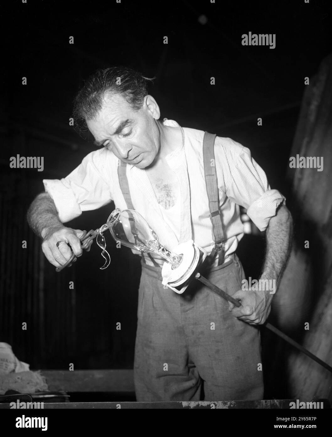 Die Sammler werden seltene Souvenirs der Krönung haben - exquisite Kelche in Diamantspitze geätzt und mit der Chiffre EIIR am 2 . Juni 1953 , überragt von der Königlichen Krone . Die Kelche der Glashütte Whitefriars , Wealdstone , Middlesex produziert Frank Hill , einer der führenden Glasbläser der Welt . Das Bild zeigt: Frank Hill formt geschickt einen Krönungskelch aus dem geschmolzenen Glas. 30. Juli 1952 Stockfoto