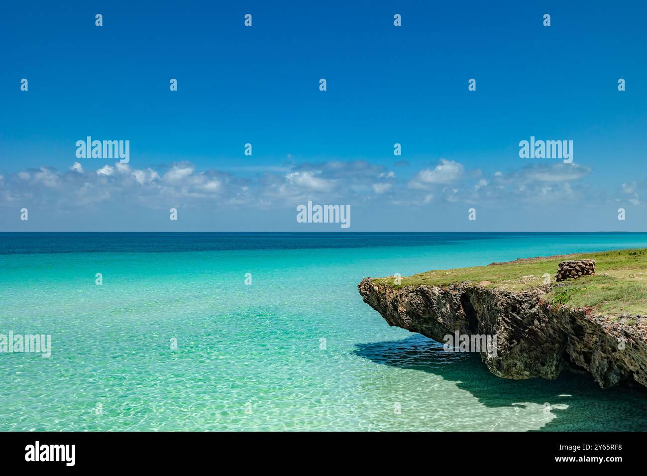 Atemberaubendes türkisfarbenes Wasser trifft auf eine felsige Küste in Varadero, Kuba. Unter einem hellblauen Himmel schafft das klare Meer eine ruhige tropische Landschaft, perfekt Stockfoto