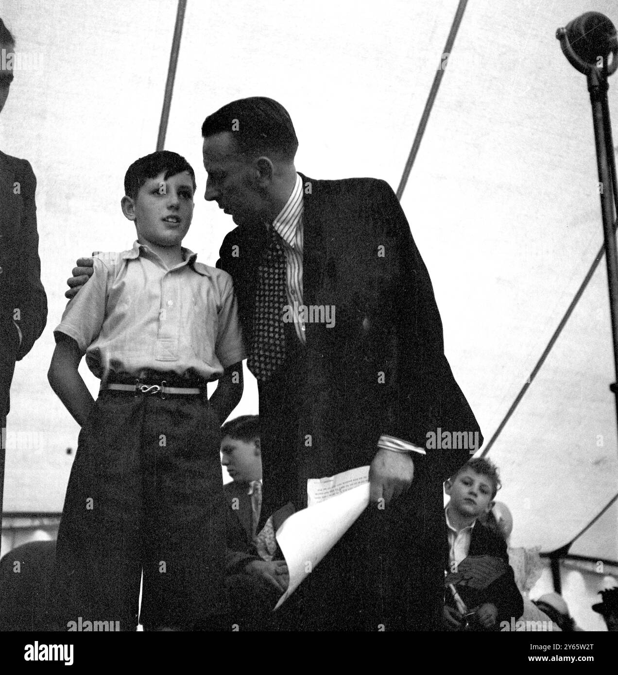 Der Radiomoderator Wilfred Pickles spricht mit einem kleinen Jungen während einer Live-Übertragung der populären Radiosendung der BBC " Have A Go " . 1948 Stockfoto