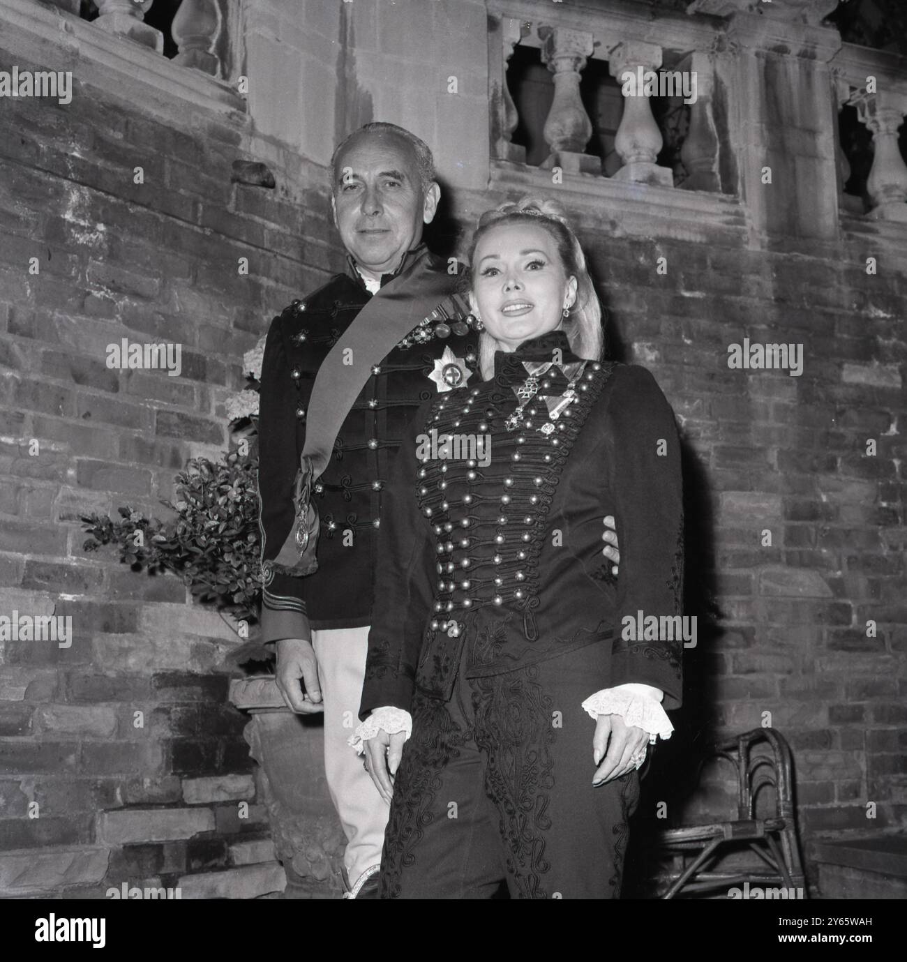 Zsa Zsa Gabor in einer anscheinend ruuritanischen Uniform und ihr ähnlich gekleideter vierter Ehemann Herbert Hutner sind in einem Londoner Hotel abgebildet . Juli 1964 Stockfoto