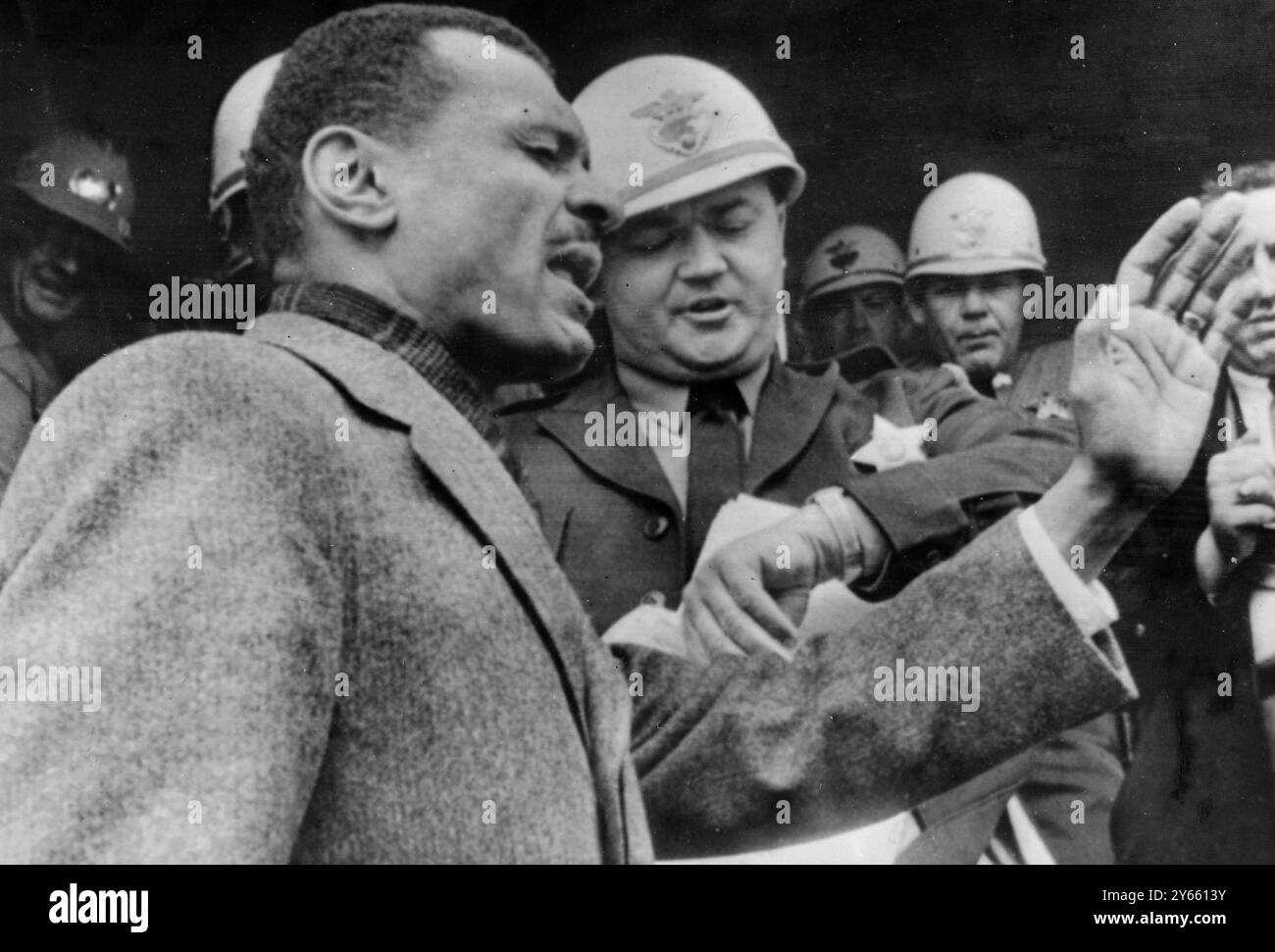 Selma , Alabama : Rev C. T. Vivian (im Vordergrund ) führt gestern ein Gebet auf den Stufen des County Court House, während Sheriff Jim Clark ( Mitte ) auf seine Uhr blickt und Vivian erzählt : die Zeit ist vorbei . Vivian leitete das Gebet , nachdem ihm und einer Gruppe von Anhängern der Zutritt zum Gerichtsgebäude von Clark verweigert wurde , der die Gruppe später verhaftete . 6. Februar 1965 Stockfoto