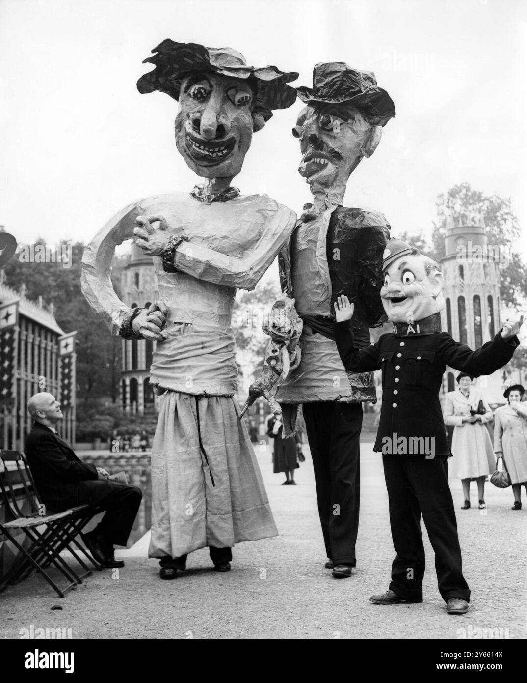 Riesenfiguren sorgten für eine Karnevalsatmosphäre in den Festival Pleasure Gardens im Battersea Park, als es für die erste Karnevalsfeier eine volle Probe gab. Der Besucher der Pleasure Gardens, der auf einem Sitzplatz steht, sieht bei einem Spaziergang riesige Figuren an. Teil des Festivals of Britain am 3. Oktober 1951 Stockfoto