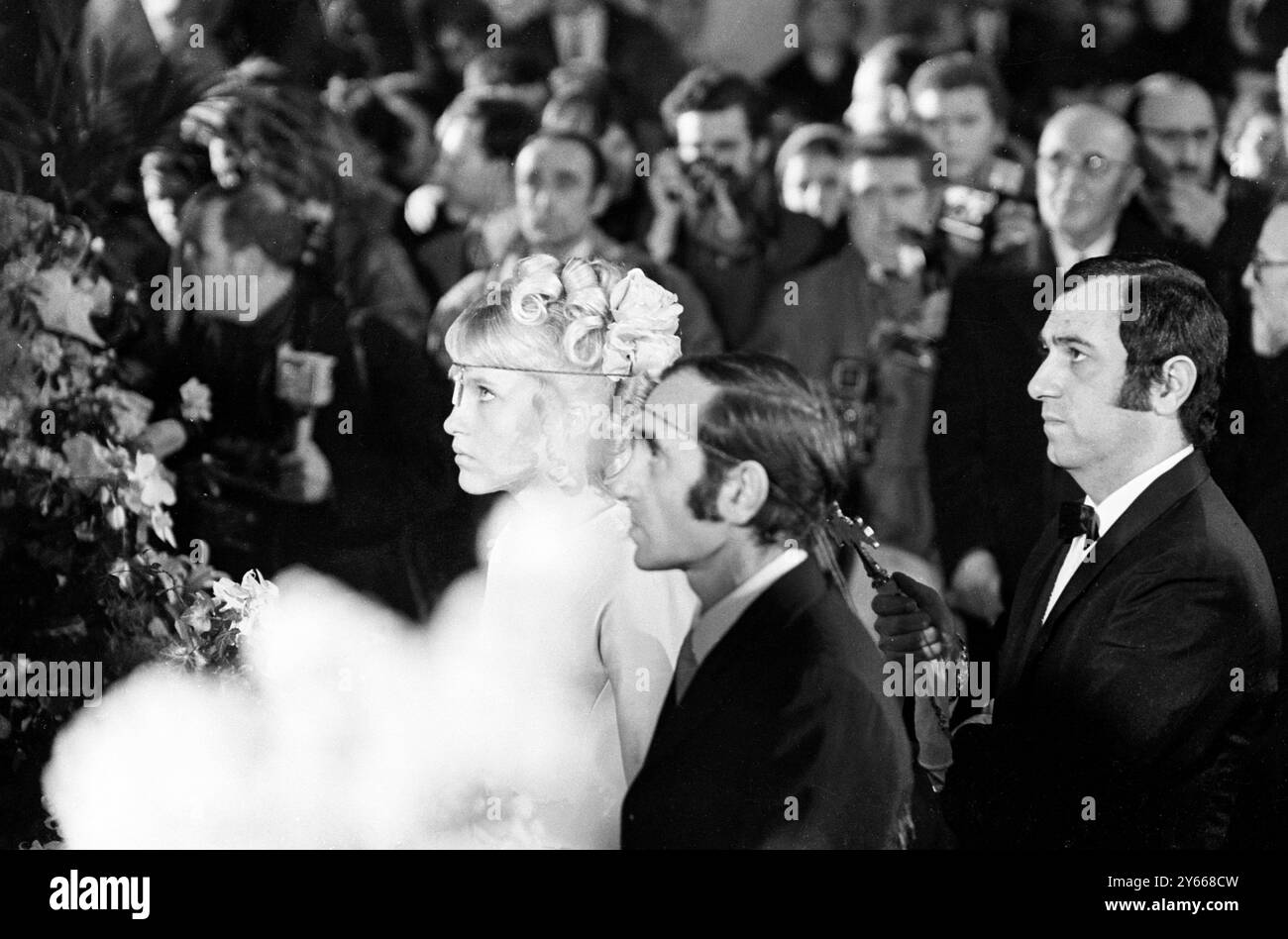 Der französische Sänger Charles Aznavour und seine hübsche, hellhaarige Braut Ulla Thorsell , Tochter einer Reinigungskraft in Schweden , werden am 12 . Januar 1968 in der winzigen armenischen Kathedrale in Paris bei ihrer religiösen Hochzeitszeremonie gesehen . Die Zeremonie fand genau ein Jahr nach der standesamtlichen Eheschließung des Paares in Las Vegas statt. Aznavour , 43 , war vor dem .15. Januar 1968 zweimal verheiratet Stockfoto