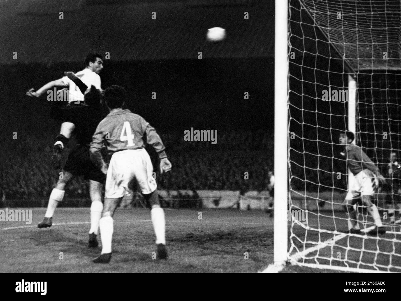 England unter 23 International England gegen Bulgarien an der Stamford Bridge. Bulgariens rechte Hälfte Lyargov (Nr. 4) beobachtet, wie sein Torhüter Parchanov von England, dem rechten Außenseiter Peter Brabrook, zu einem hohen Ball geschlagen wird. September 1957 Stockfoto