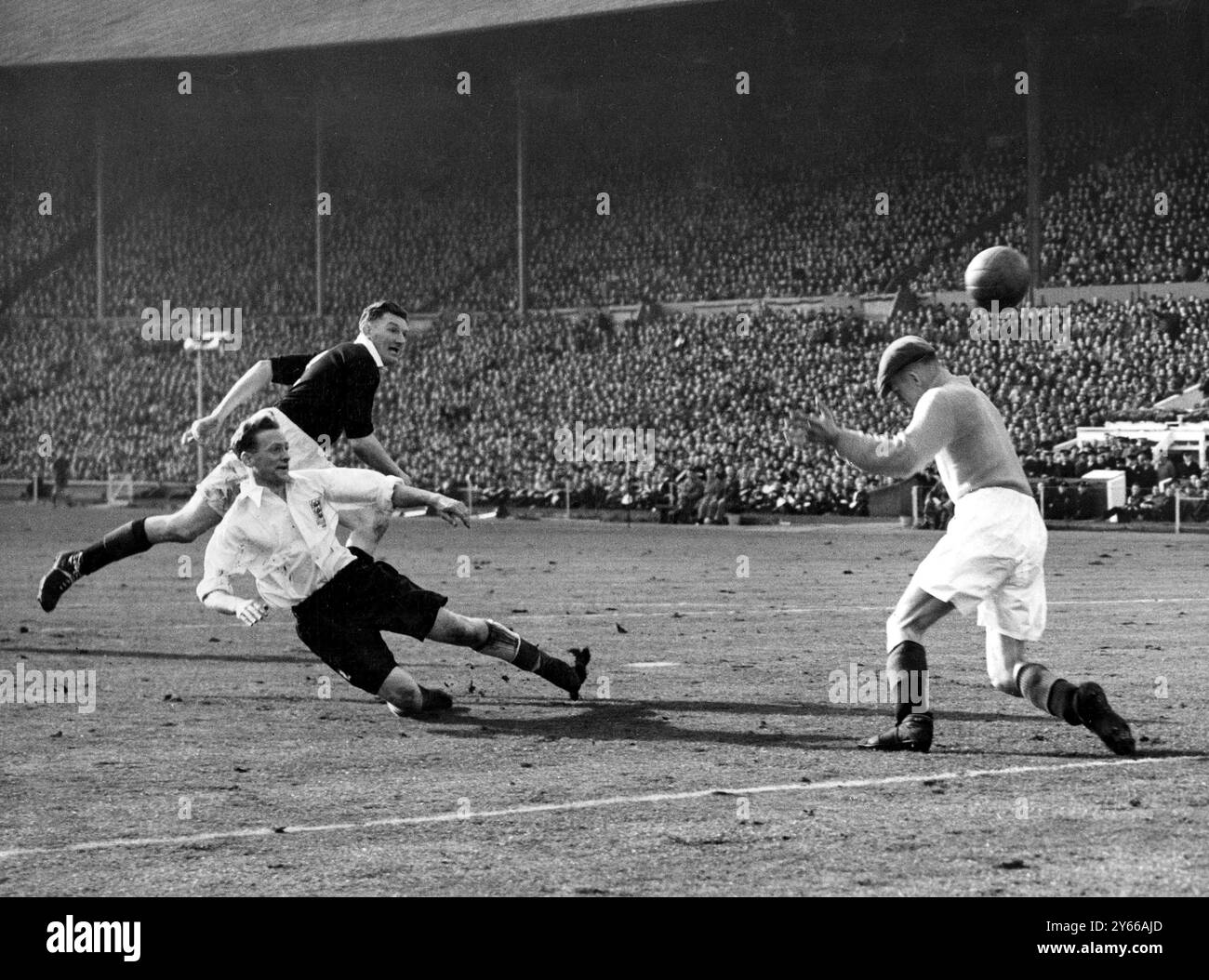 England gegen Schottland im Wembley Stadium. Engalnds zweites Tor wurde von Tom Finney (Preston North End) erzielt. Finney schlägt den Ball über Jimmy Cowan (Morton), Schottlands Torwart. Hinter Finney steht George Young (Glasgow Rangers) Schottlands Rechtsverteidiger und Kapitän. April 1951 Stockfoto