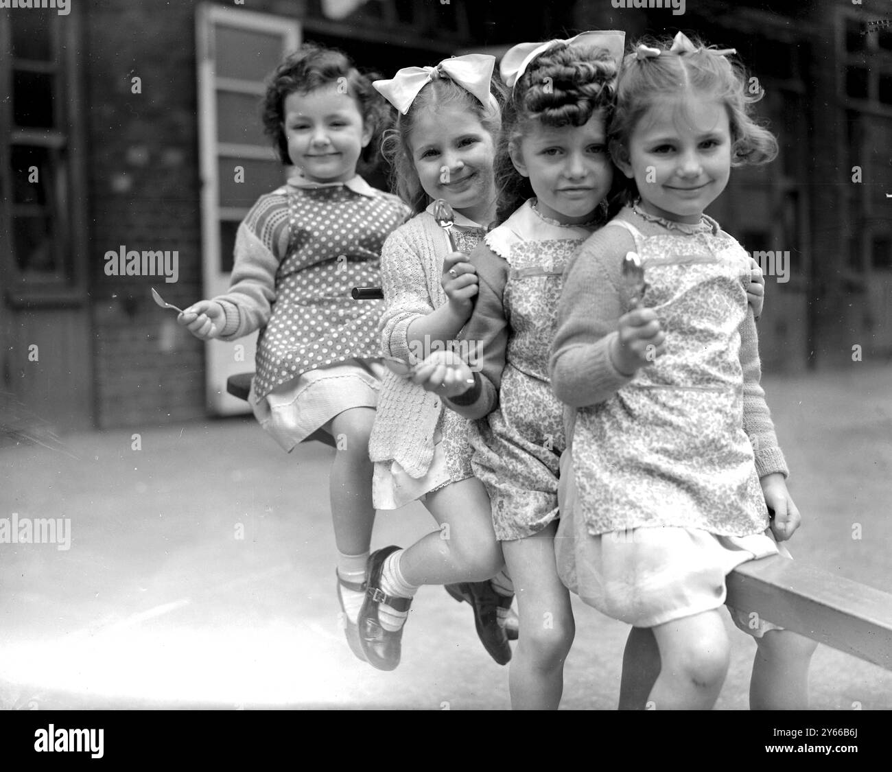 London: Von links nach rechts: Christine Cane, Pauline Amos, June Hurst und Christine Milne. Mit ihren Krönungs-Souvenirlöffeln, die ihnen an der Wilmot School in Bethnal Green London präsentiert wurden. Mai 1953 Stockfoto
