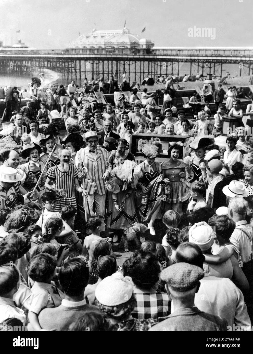 Brighton: Auf der Lower Esplanade in Brighton sehen die Holiday Crowds eine Tanznummer von den Showgirls der Max Bygraves Holiday Show. Seine Kompanie tourte mit Fassorgel an der Küste, um Brightons Bemühungen um den National Fund for Poliomyelitis zu unterstützen. August 1954 Stockfoto