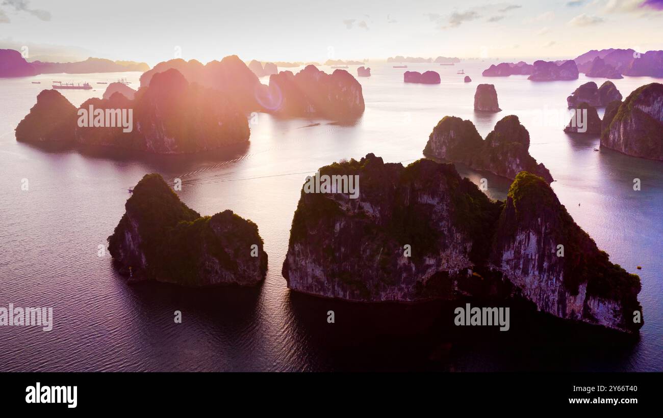 Spektakulärer Blick auf den Sonnenaufgang von Ha Long Bay mit dramatischem Himmel von der Drohne. Luftpanorama mit bewölktem Himmel am frühen Morgen. Stockfoto