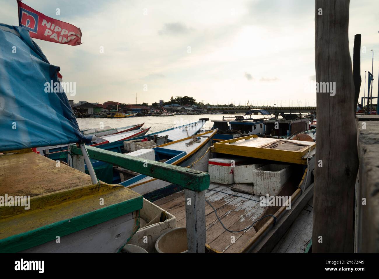 Die Fischerboote lehnen sich am Hafenpier mit einem wunderschönen Blick auf den Abendhimmel Stockfoto