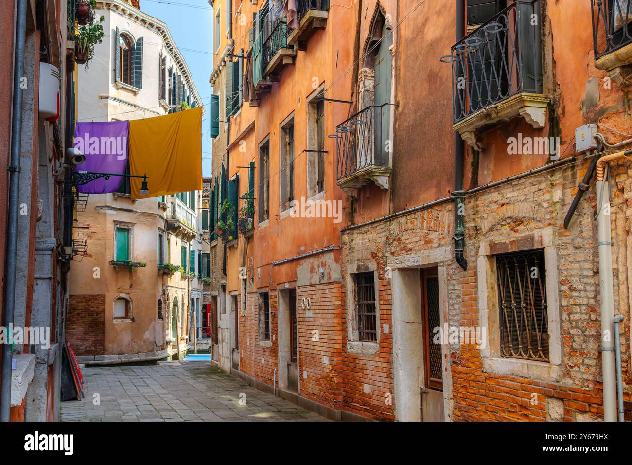 Waschen hängt zum Trocknen auf einer Linie zwischen zwei Gebäuden entlang des Rio Terà de le Carampane im Sestiere von San Polo, Venedig, Italien Stockfoto