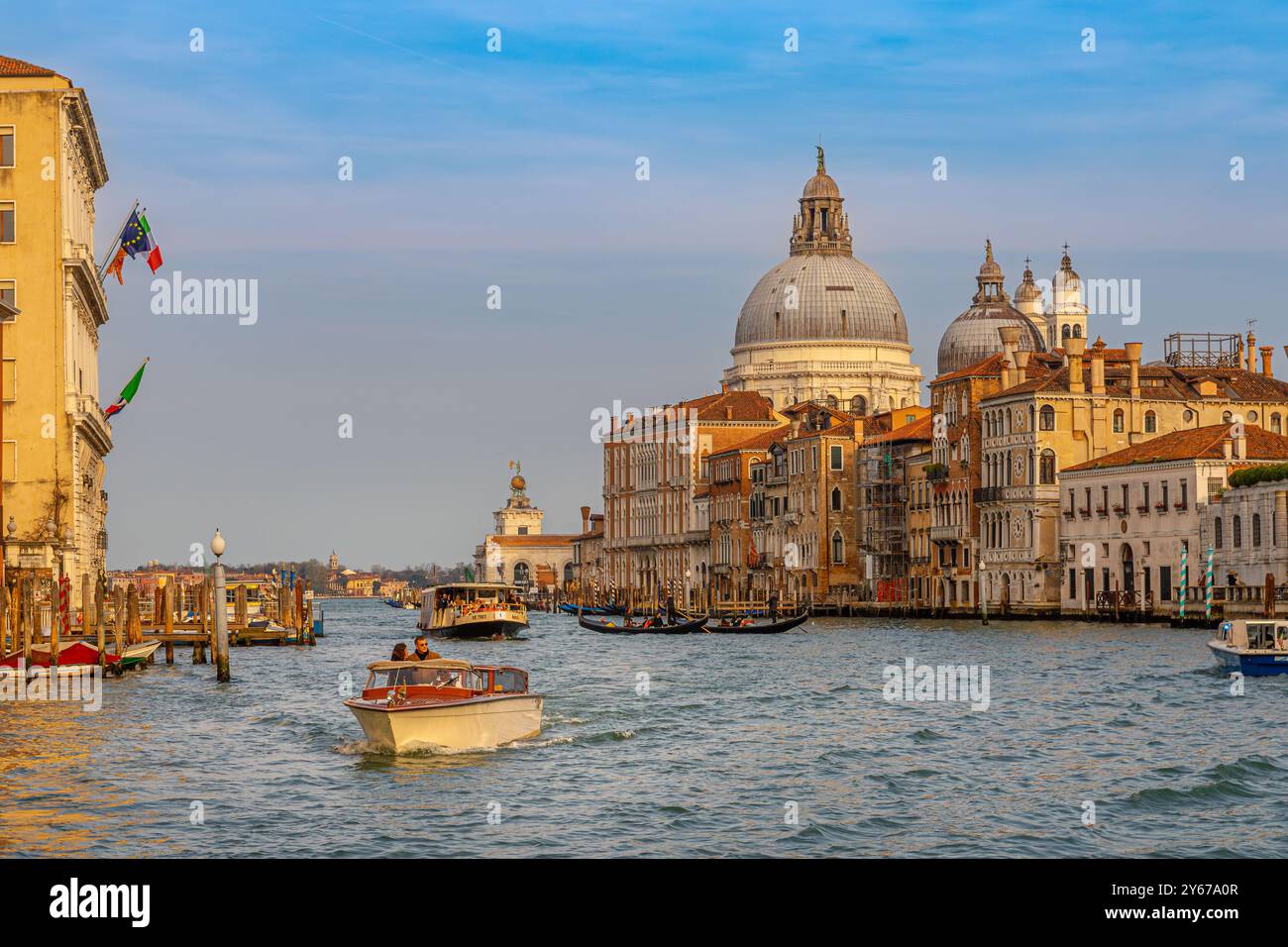 Ein Wassertaxi fährt entlang des Canal Grande mit der Basilika Santa Maria della Salute im Hintergrund, Venedig, Italien Stockfoto