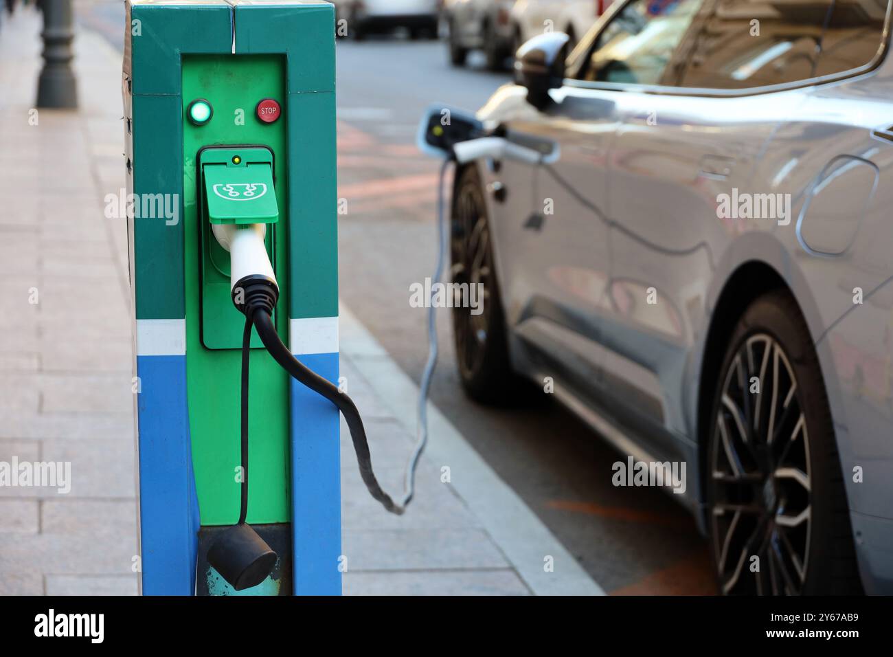 Laden von Elektroautos, umweltfreundlicher Transport. Ladestation an einer Straße in der Stadt Stockfoto