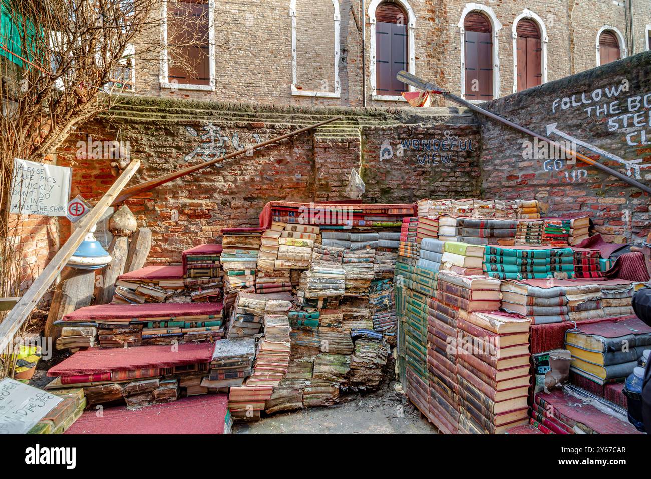 Stufen aus alten Büchern, so dass man über die Wand auf der Rückseite des Liberia Acqua Alta, einem skurrilen, beliebten Buchladen in Venedig, Italien, blicken kann Stockfoto