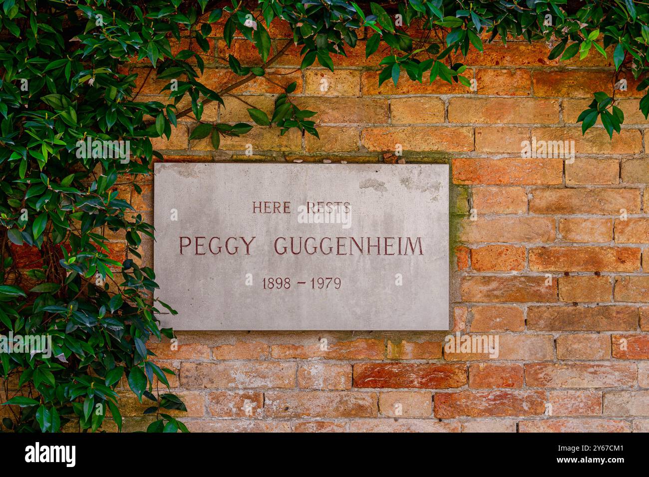Eine Steintafel an der Mauer an der Grabstätte von Peggy Guggenheim im Innenhof des Peggy Guggenheim Museums, Venedig, Italien Stockfoto