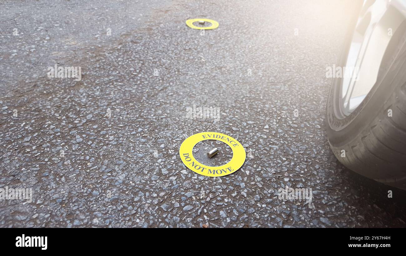Eine verschwendete Kugeln, die in einem gelben Kreis platziert sind, mit dem Textbeweis beschriftet sind, sich nicht bewegen, vor Pflasterhintergrund gestellt, Konzept des Verbrechens in Stockfoto