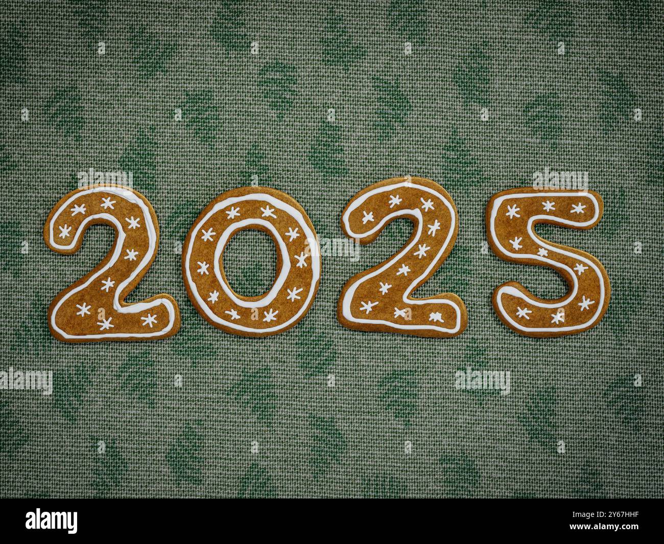 Neujahrsdatum 2025 arrangiert aus Weihnachtskuchenkeksen auf grünem Tischtuch Stockfoto