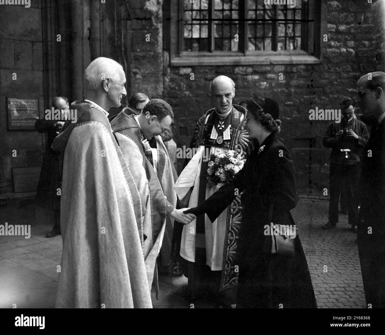 Königin besucht Maundy Service in der Abbey Ihr erstes öffentliches Engagement seit Beginn ihrer Regierungszeit als Königin wird sie von Mitgliedern des Klerus bei ihrer Ankunft in der Westminister Abbey (Mitte) begrüßt, ist Dr. Don der Dekan der Westminister Abbey am 10. April 1952 Stockfoto