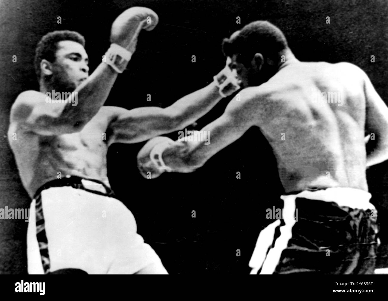 Cassius Clay (links) zieht sich von einem kurzen linken Jab von Herausforderer Floyd Patterson während der ersten Runde ihres Meisterschaftskampfes in Las Vegas, Nevada, zurück. Clay hielt einen konstanten Strom beleidigender Ratschläge aufrecht, als beide Kämpfer nach einer frühen Eröffnung suchten. Der Schiedsrichter gab Clay die erste Runde, obwohl Clay keinen Schlag erlangte. Der Schiedsrichter trat auch gegen die beiden Richter an, indem er Patterson die 11. Runde gab. November 1965 . Stockfoto