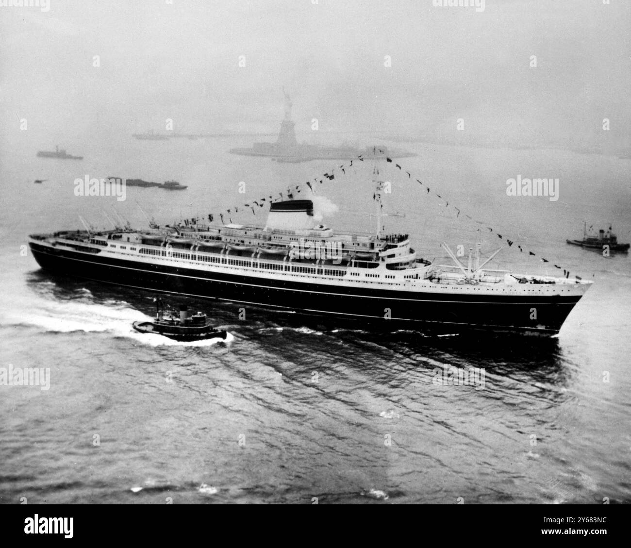 Das Ende der Jungfernfahrt des italienischen Luxusschiffes „Andrea Doria“ ging an der Freiheitsstatue vorbei. New York - 23. Januar 1953 das Schiff sank tragischerweise nach einem Zusammenstoß mit dem schwedischen Schiff 'Stockholm' 40 Meilen vor der Küste von Neuengland in dichtem Nebel. Juli 1956 Stockfoto