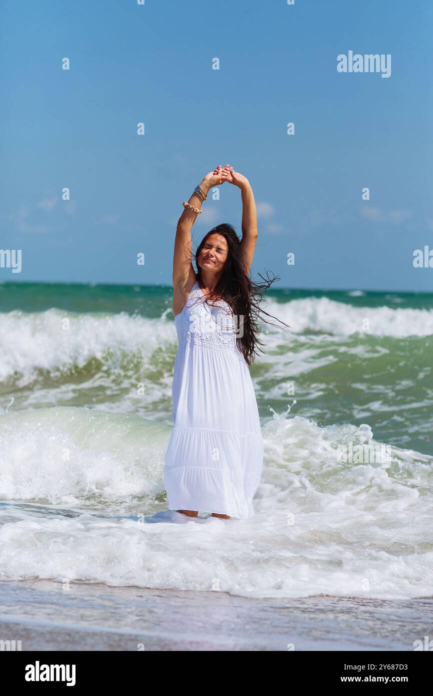 Reife Frau genießt einen gemütlichen Spaziergang am Meer Stockfoto