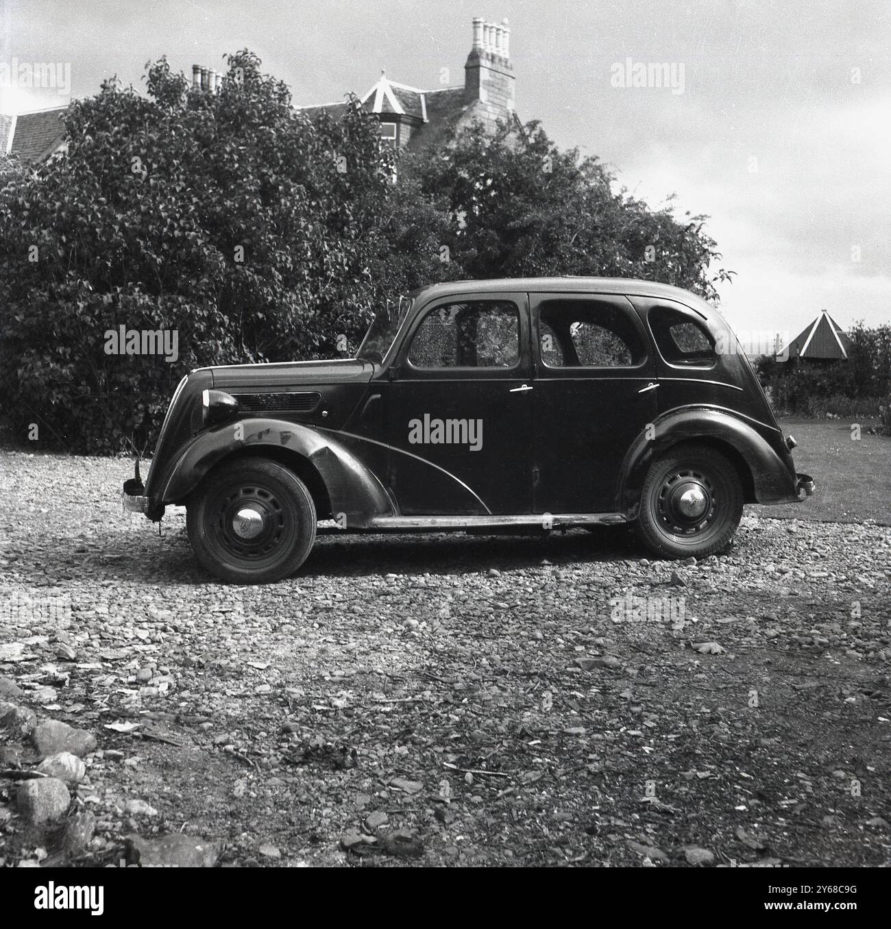 1950er Jahre, historisch, ein Ford-Auto mit zahlreichen Dellen an Radkästen... Parken in der Einfahrt in Canonbury House, Fortrose, Schottland, Großbritannien, Heimat von Colonel Arthur E. Irvine vom Royal Army Medical Corps. 1936 wurde Irvine zum Ehrenchirurgen des Vizekönigs von Indien ernannt. Stockfoto