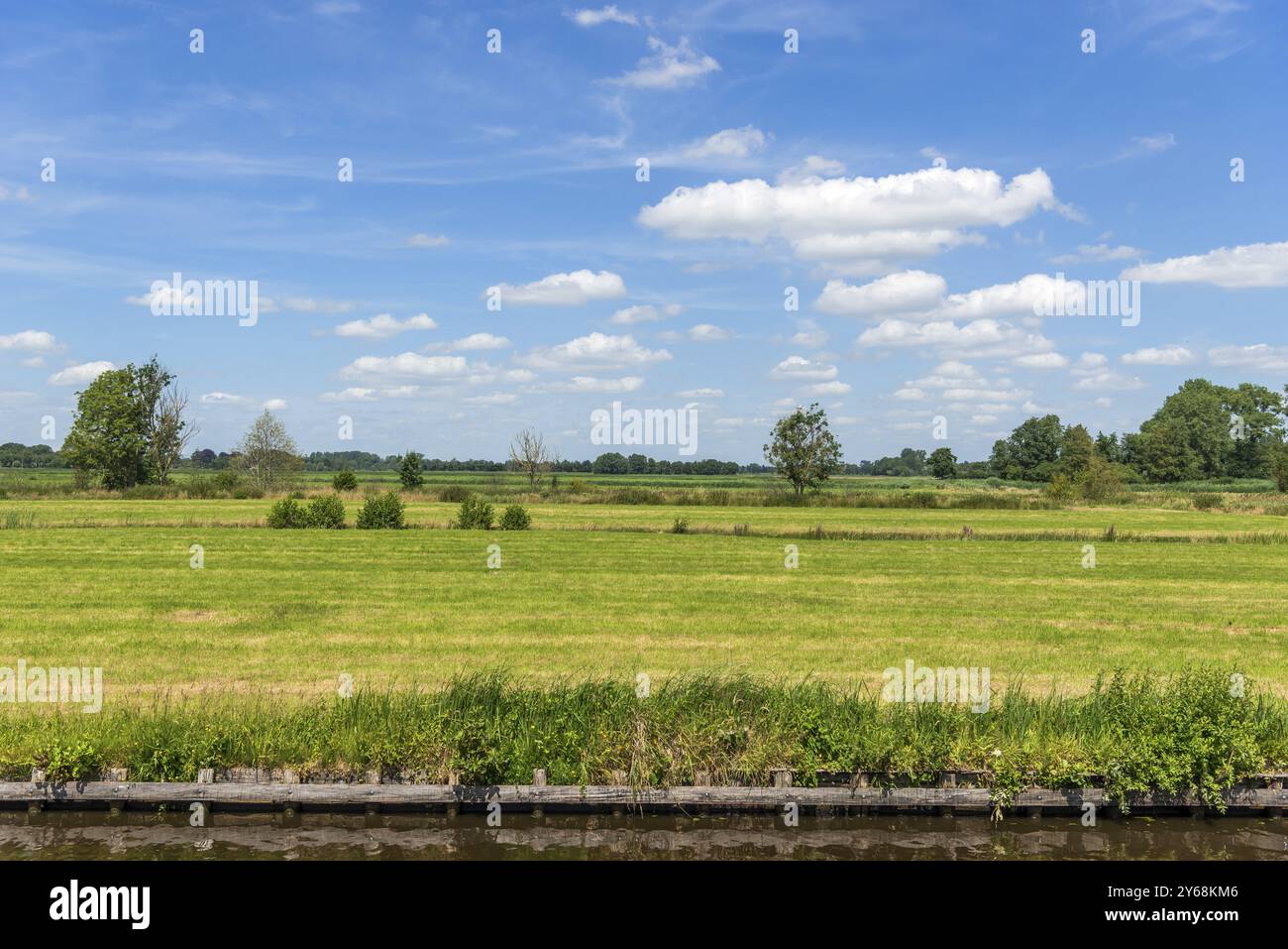 Puristische Landschaft am Kanal, flaches Land, weites Freiland, flache Ebene, blauer Himmel, Wolke, ländlich, Wiese, Gras, Giethoorn, Niederlande Stockfoto