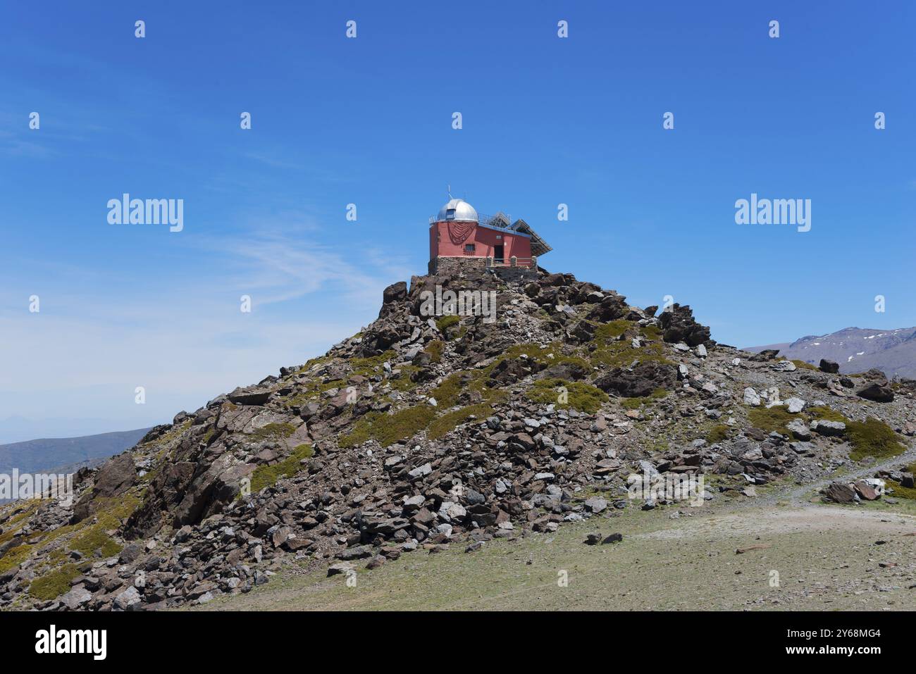 Rotes Observatoriumsgebäude auf einem felsigen Hügel unter blauem Himmel, Obversatorium, Mohon del Trigo Observatorio, Observatorio del Mojon del Trigo, Gueejar Si Stockfoto