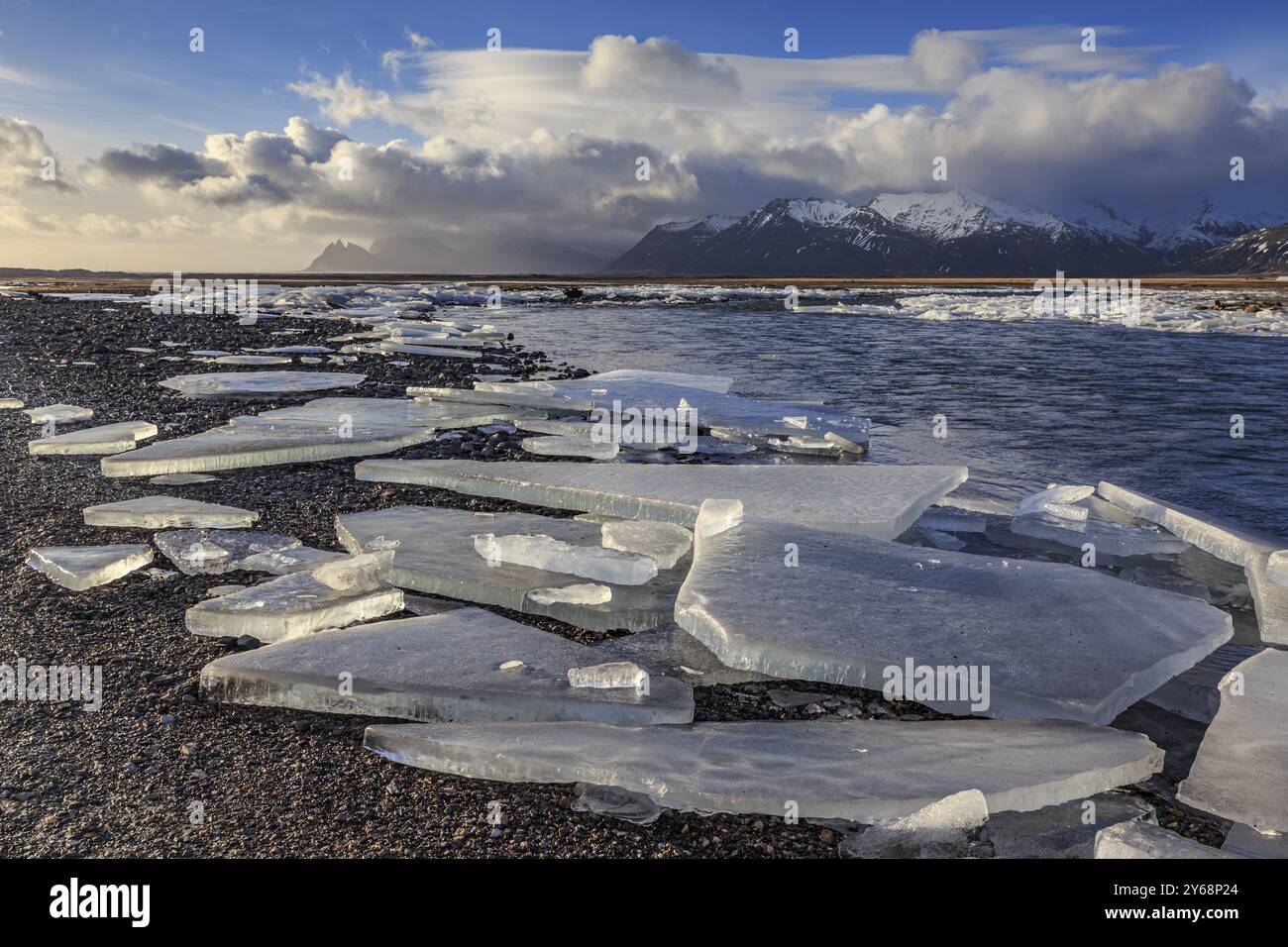 Eisschollen am Strand, Schnee, Wellen, Meer, bewölkte Stimmung, Winter, Lonsvik, Hoefn, Island, Europa Stockfoto