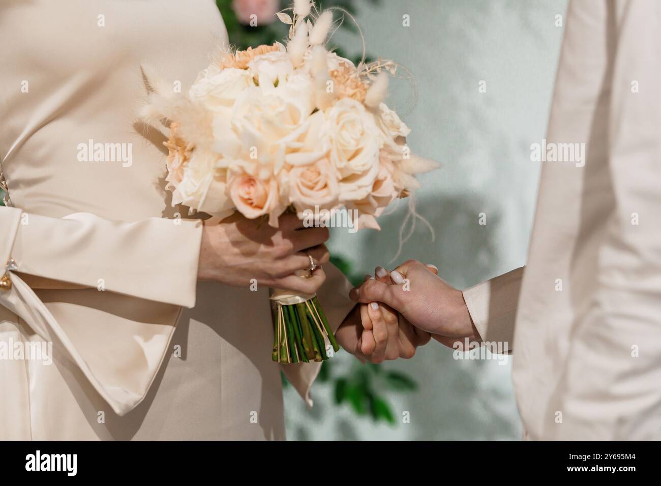 Eleganter Brautstrauß-Austausch in weichen Pastelltönen, aufgenommen während einer intimen Hochzeitszeremonie. Stockfoto