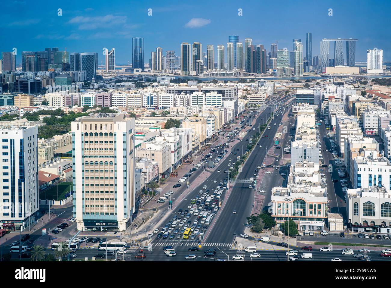 Blick aus der Vogelperspektive auf Abu Dhabis Defense Street, die von hohen und mittleren Gebäuden flankiert ist. Die modernen Wolkenkratzer von Al Reem Island Stockfoto