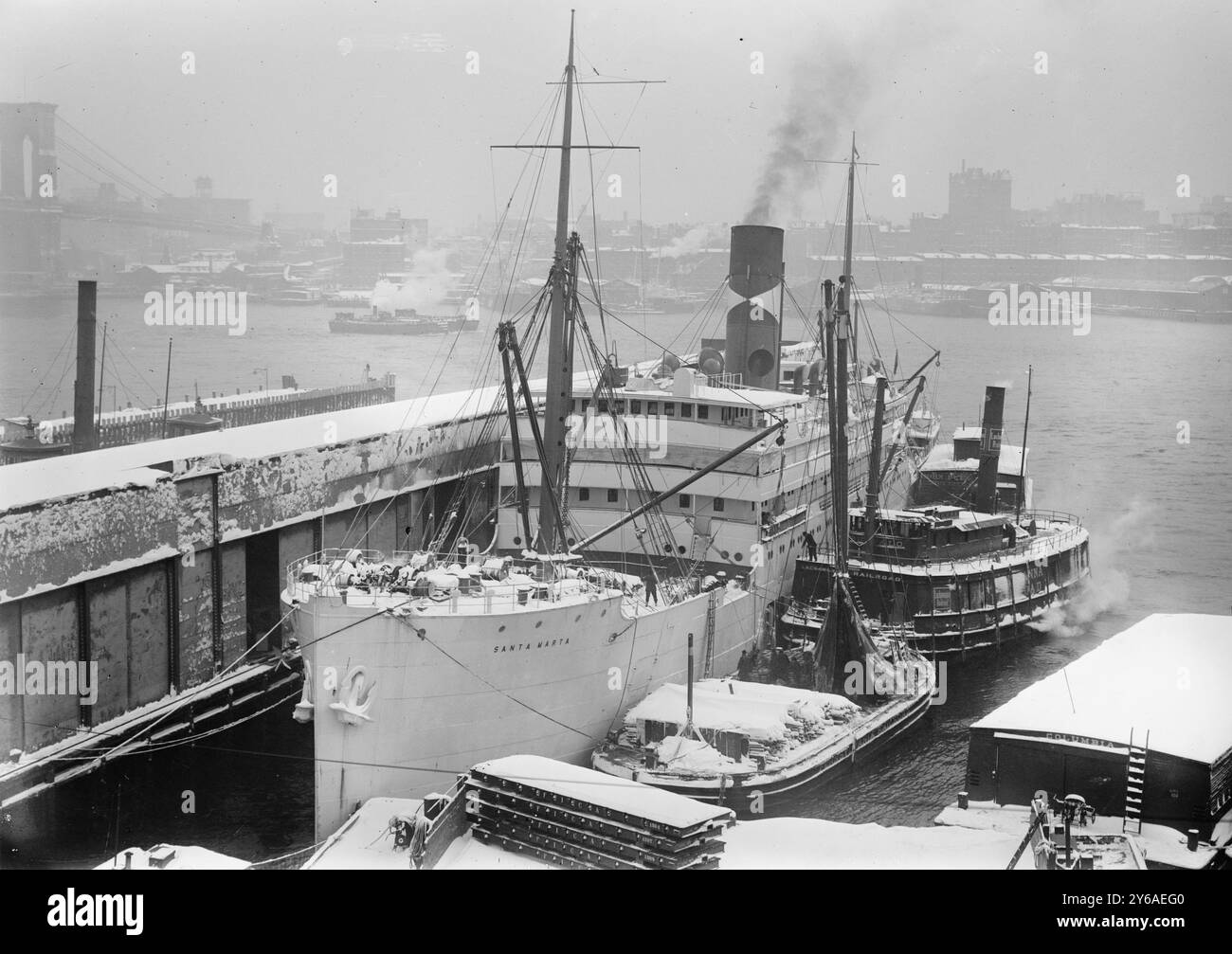 Santa Marta, Foto zeigt die Santa Marta (gebaut 1909), einen gekühlten Obsttransport („Bananenboot“) an einem East River Dock in New York City, mit Brooklyn Bridge im Hintergrund. Die Santa Marta wurde auch verwendet, um Elemente des US Army Base Hospital 22 im März 1919 von Frankreich nach New York zu transportieren, zwischen ca. 1910 und ca. 1915, Glasnegative, 1 negativ: Glas; 5 x 7 Zoll. Oder kleiner. Stockfoto