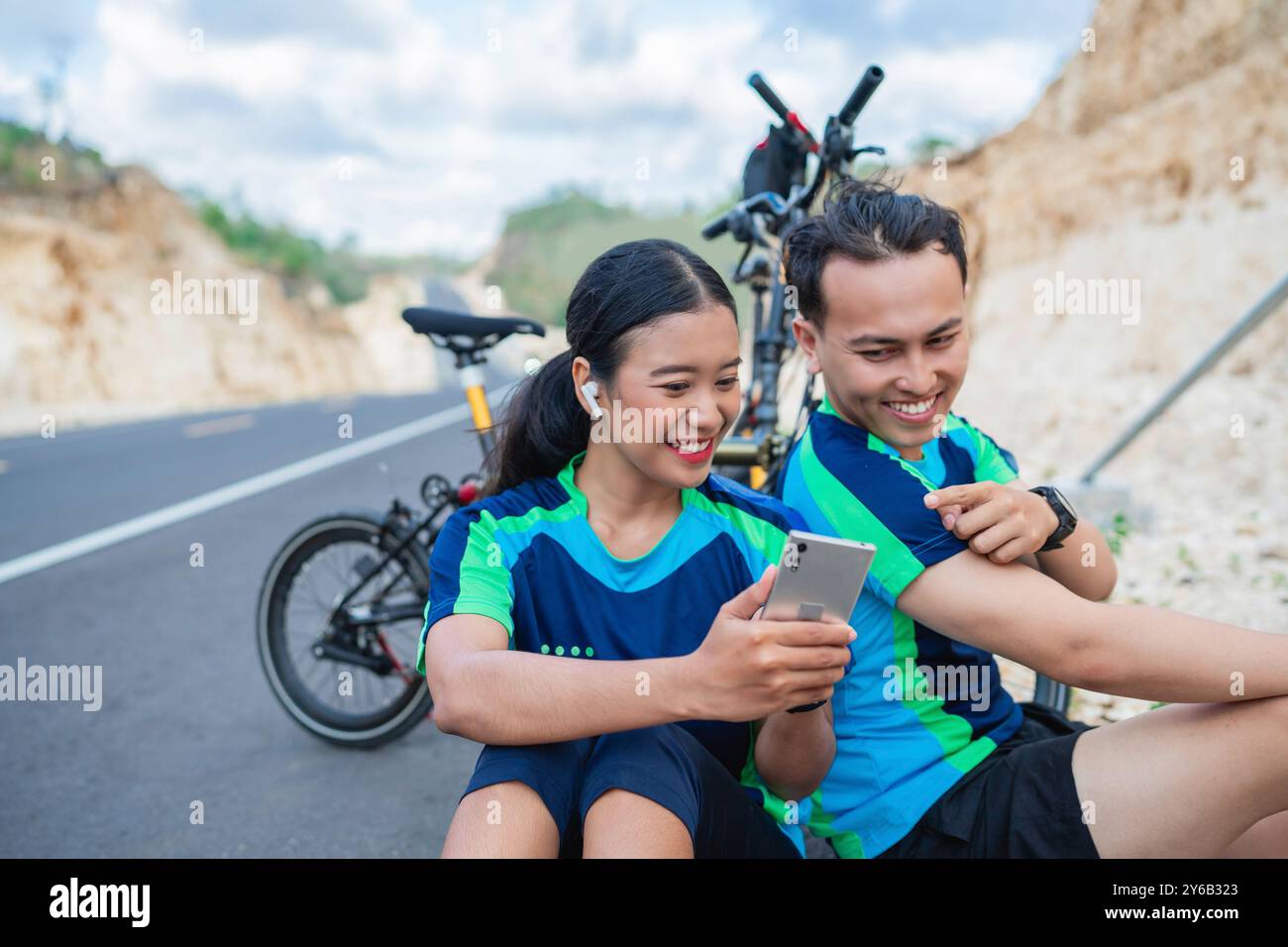 Weibliche Bikerin, die das Telefon hält, und männliche Bikergeste Stockfoto