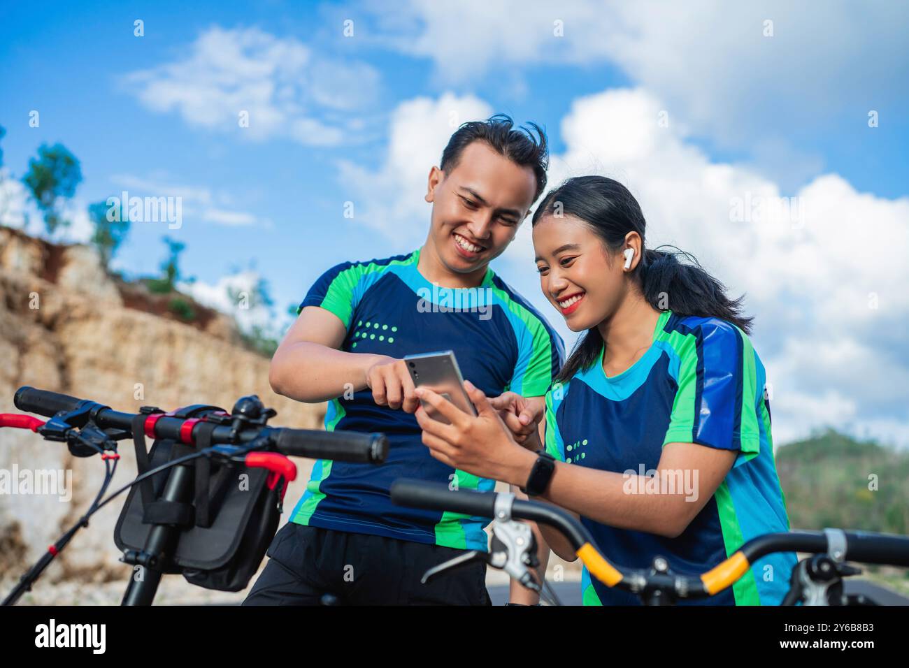 Weibliche und männliche Radfahrer mit Telefon, Fahrrad fahren Stockfoto