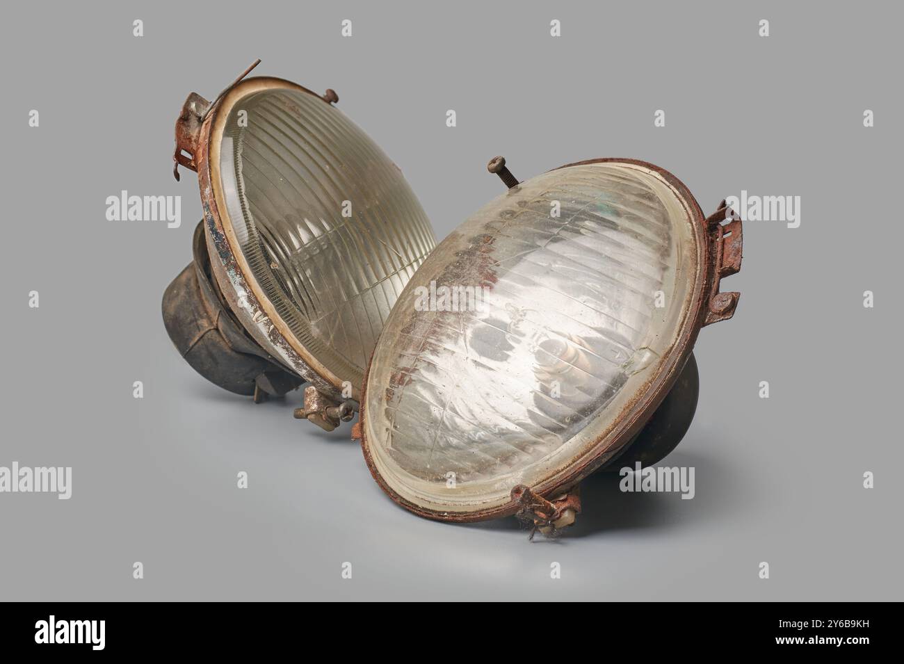 Alte, entsorgte Autoscheinwerfer isolierter grauer Hintergrund, Ersatzteile in Schrottplatz-Nahsicht, beschädigte veraltete oder nicht mehr funktionsfähige Fahrzeugteile Stockfoto