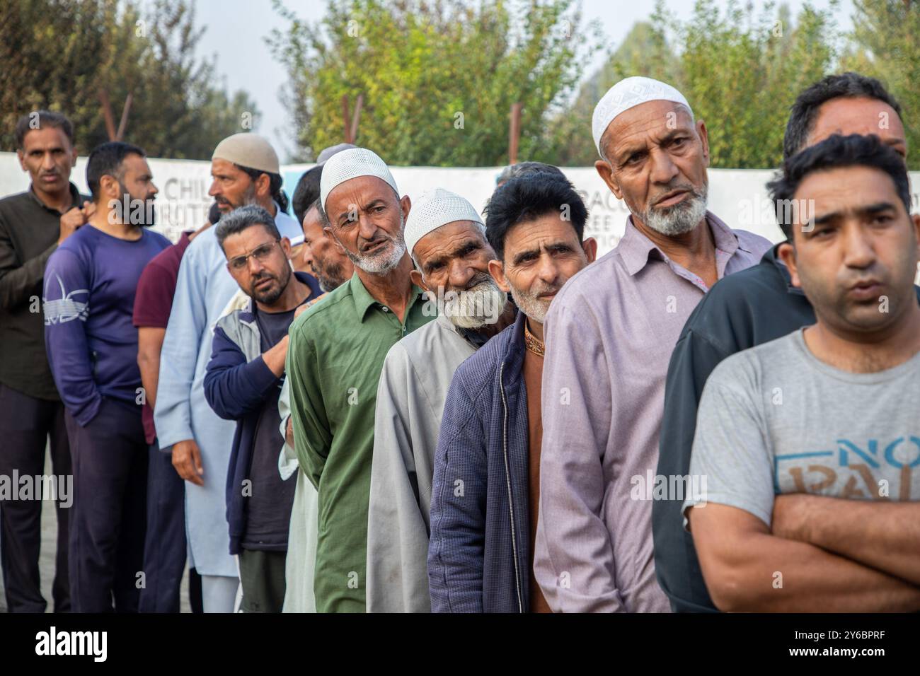 Kaschmir-Wähler warten in einer Warteschlange, um ihre Stimmzettel vor dem Wahlhaus abzugeben, während der zweiten Phase der Parlamentswahlen in Jammu und Kaschmir am Stadtrand von Srinagar. Dies sind die ersten Kommunalwahlen seit einem Jahrzehnt und die ersten, seit Neu-Delhi 2019 den halbautonomen Status der Region widerrief und sie unter direkte Herrschaft stellte. Fast neun Millionen Menschen sind registriert, um in der umstrittenen Region zu wählen, die traditionell für Boykotte aus Protest gegen die indische Herrschaft bekannt ist. (Foto: Faisal Bashir/SOPA Images/SIPA USA) Stockfoto