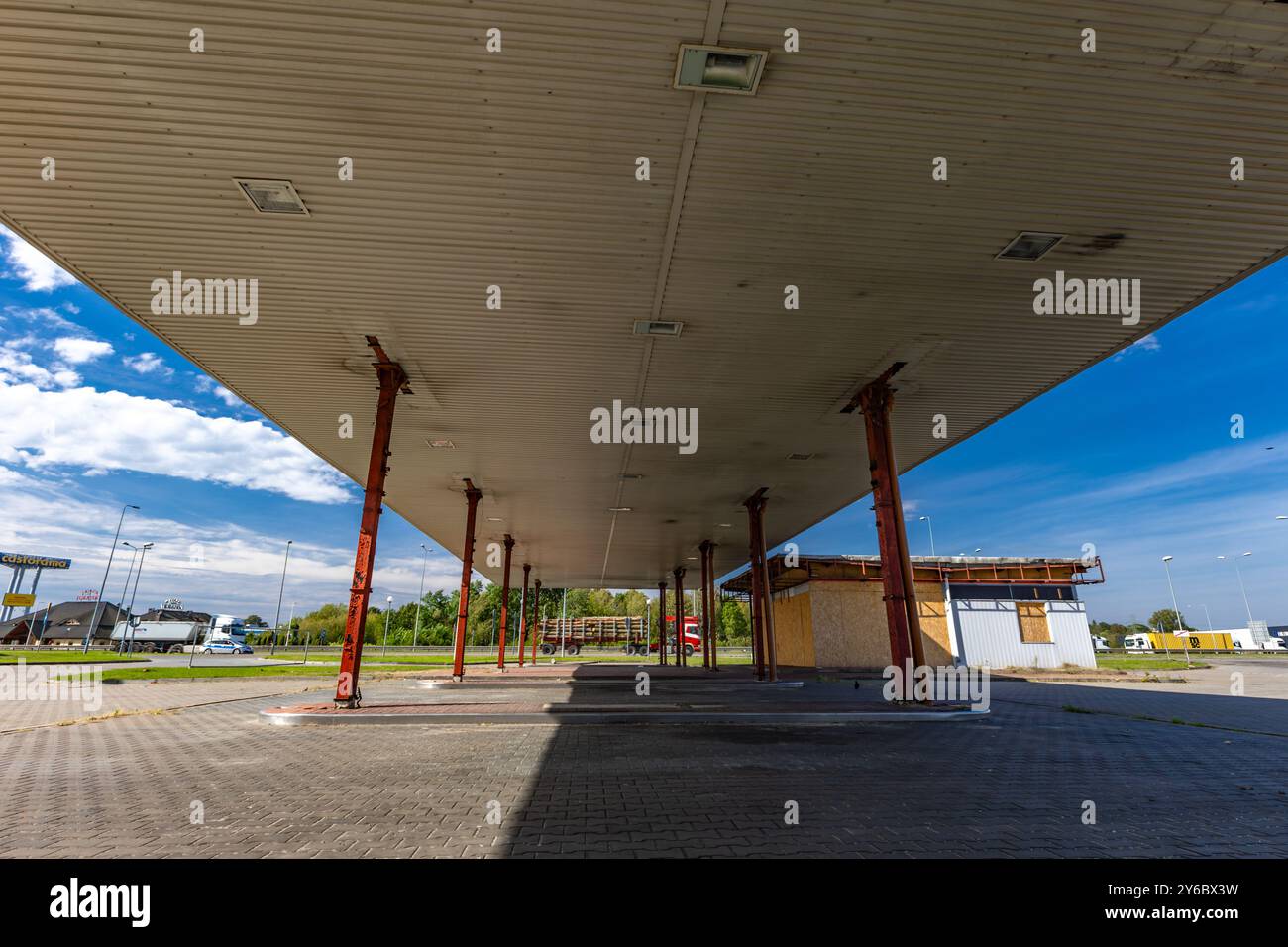 Inaktive und verlassene Tankstelle, inaktive Spender, verschobene Fenster, umzäunter Bereich, alter Bahnhof im Stadtzentrum an der Schnellstraße Stockfoto