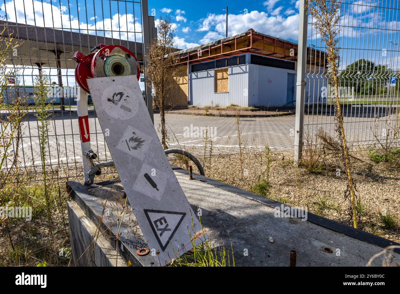 Inaktive und verlassene Tankstelle, inaktive Spender, verschobene Fenster, umzäunter Bereich, alter Bahnhof im Stadtzentrum an der Schnellstraße Stockfoto