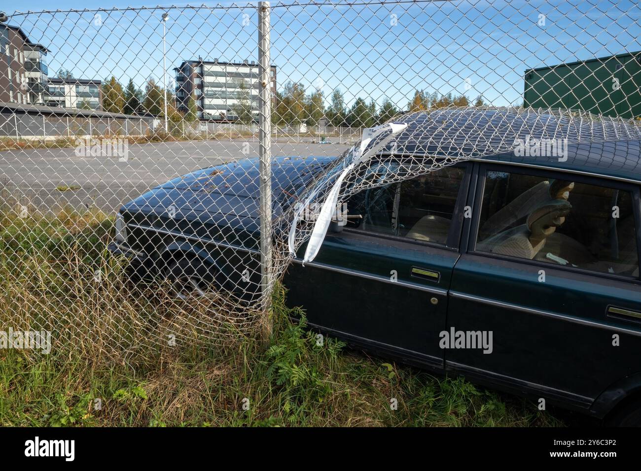 Das Auto ist durch den Maschendrahtzaun gestürzt Stockfoto